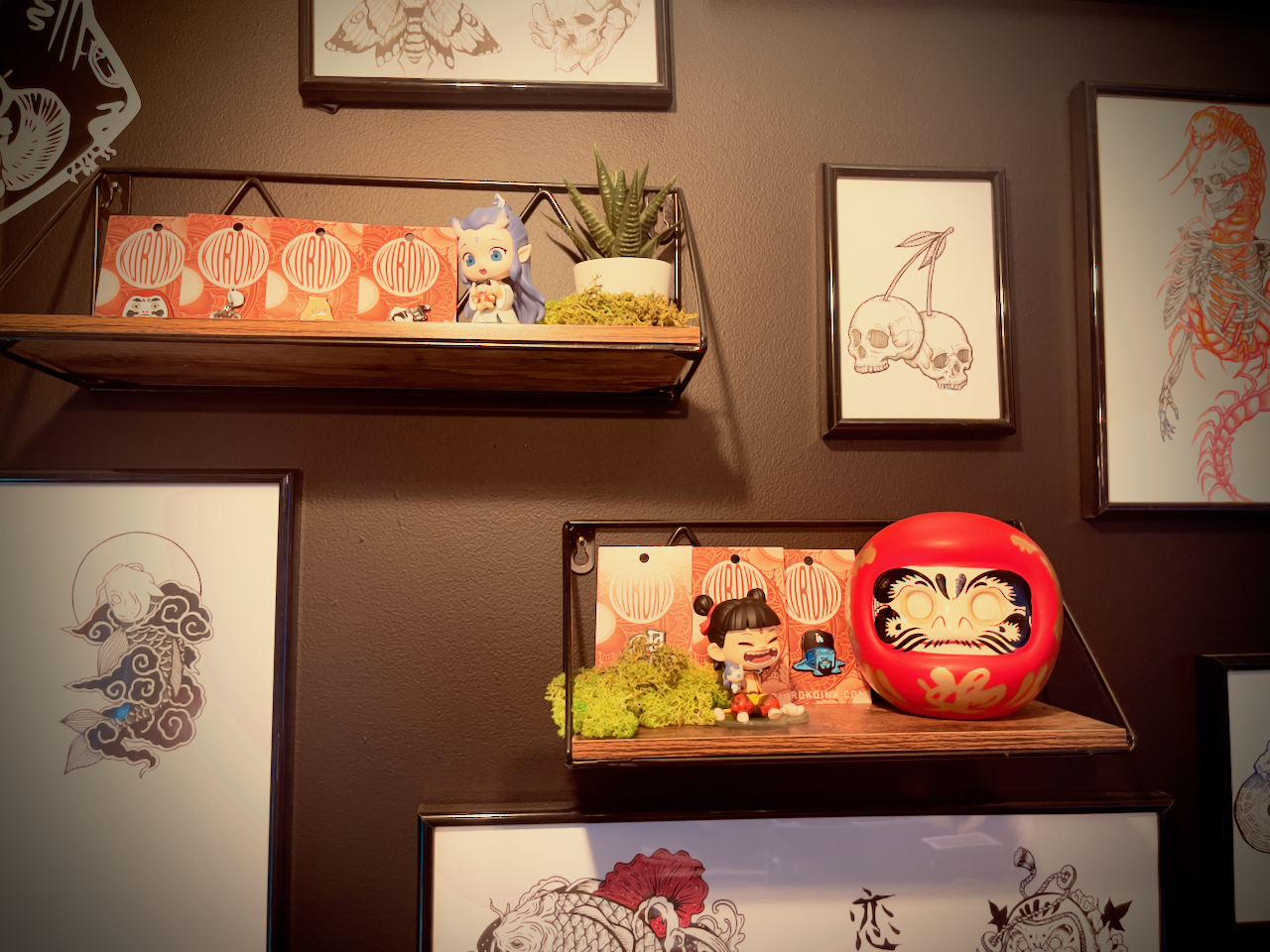Studio shelf with framed artwork, decor, and Kuroko display pieces