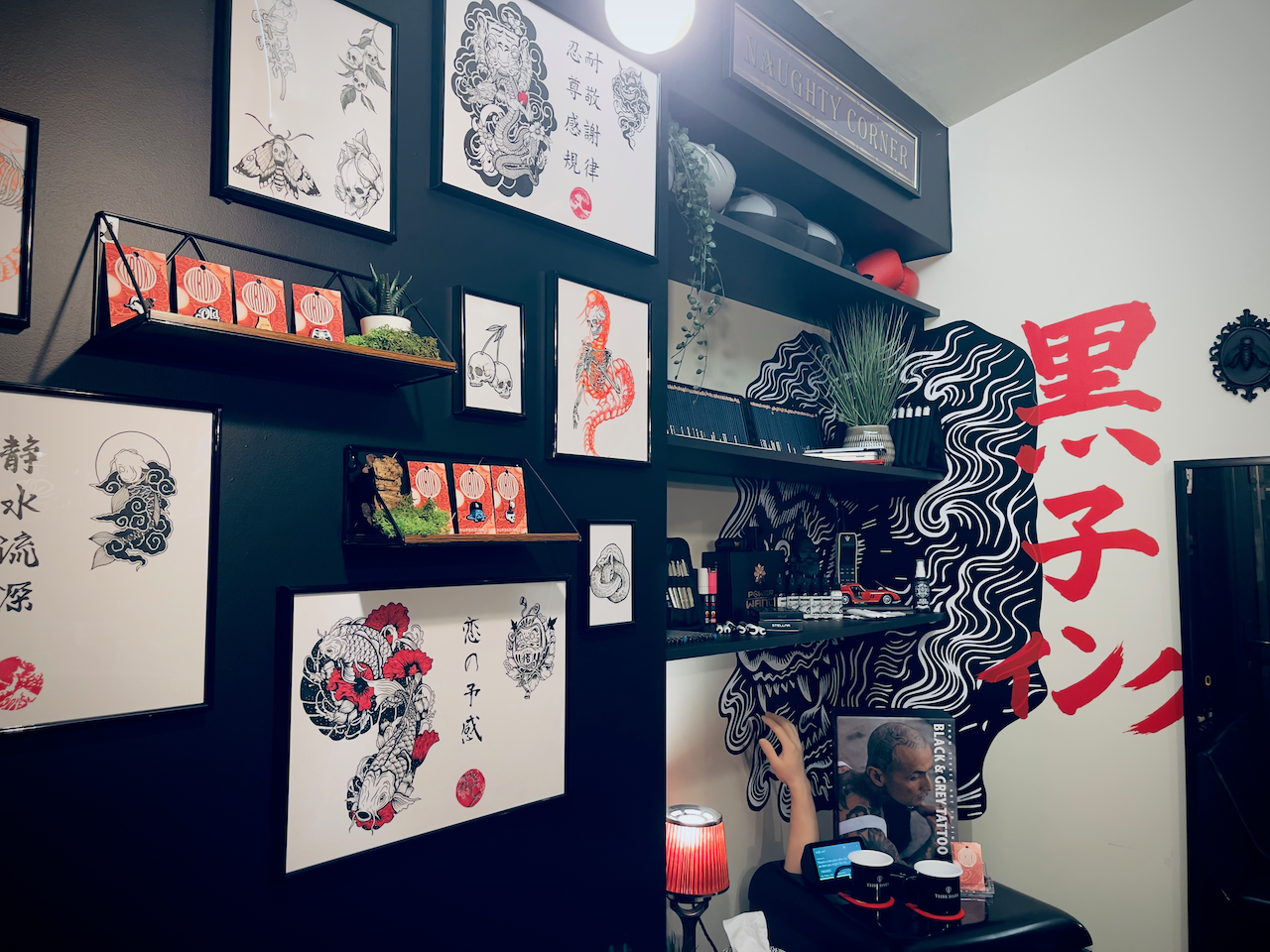 Framed artwork and display corner inside Kuroko Ink studio