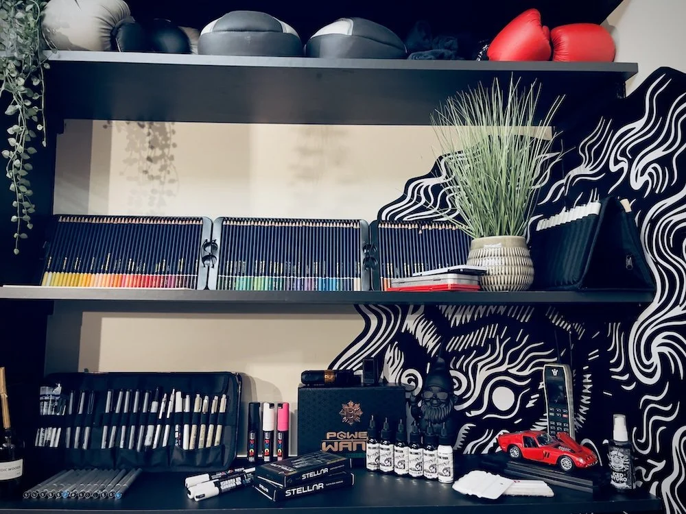 Studio shelving with drawing tools, supplies, and decor at Kuroko Ink
