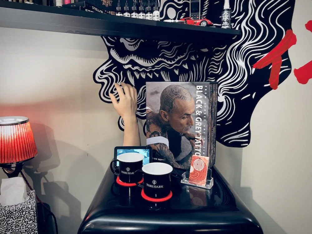 Studio display corner with art books, products, and decor at Kuroko Ink