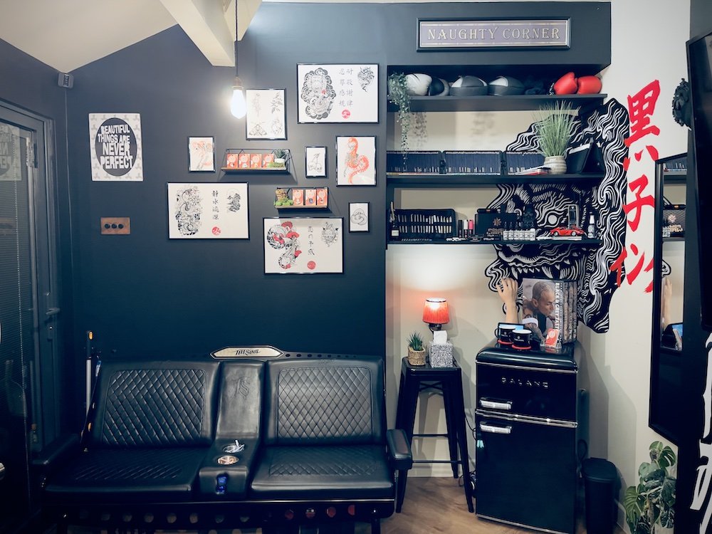 Kuroko Ink studio waiting area with framed artwork and display wall