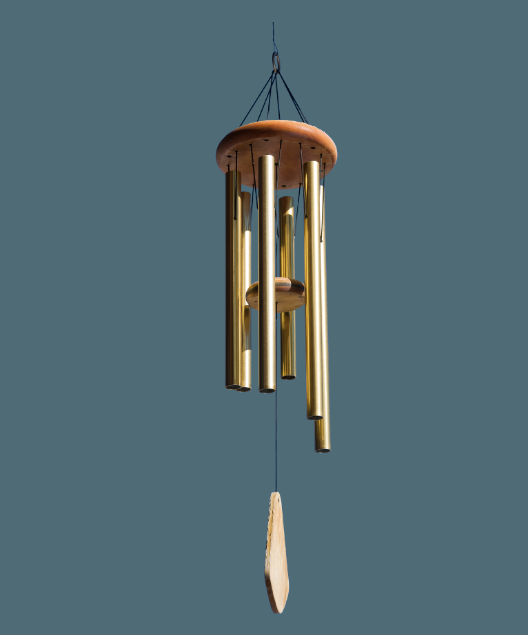 brass colored wind chime against a blue green background