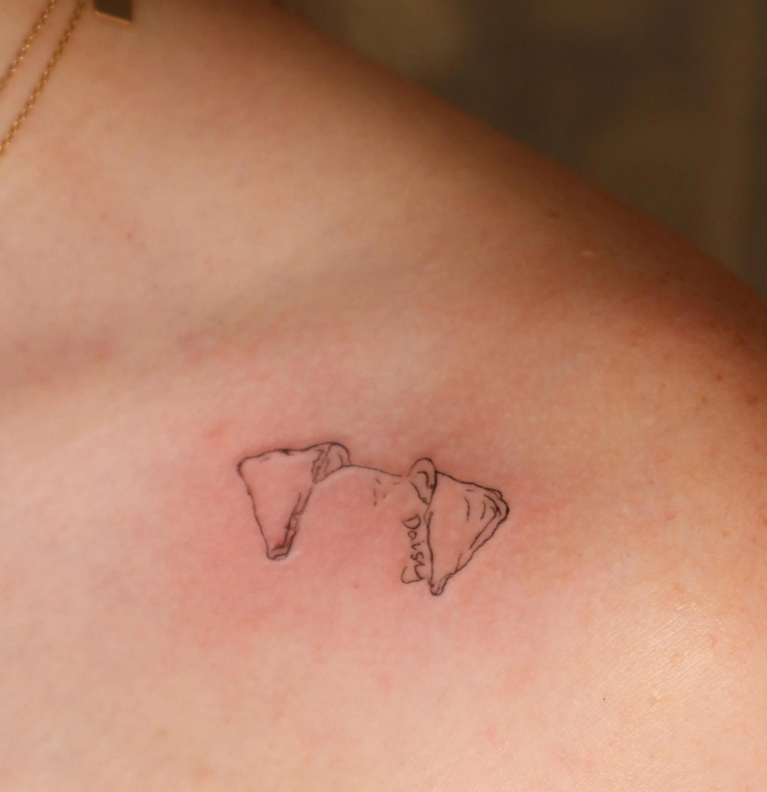 Tattoo of a broken heart with the word 'Darling' on a person's shoulder