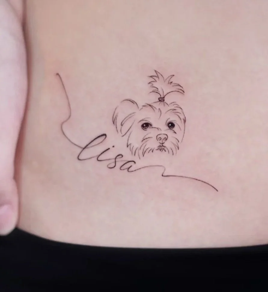 Tattoo of a dog's face with the hair tied up, with the name Lisa written in cursive below.