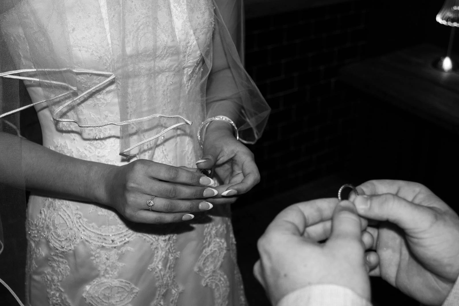 bride and groom holding rings in ceremony