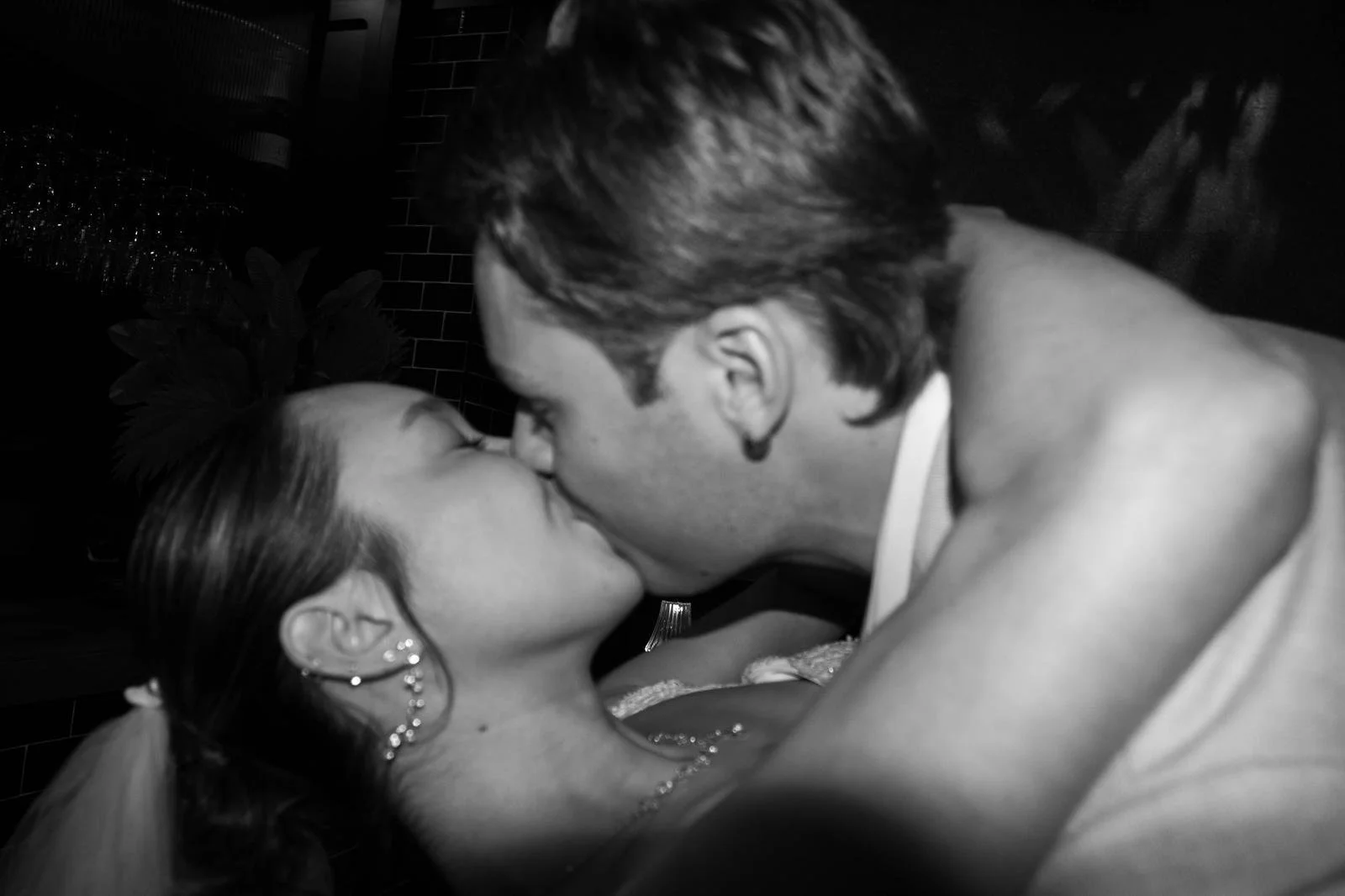 black and white photo of bride and grooms first kiss