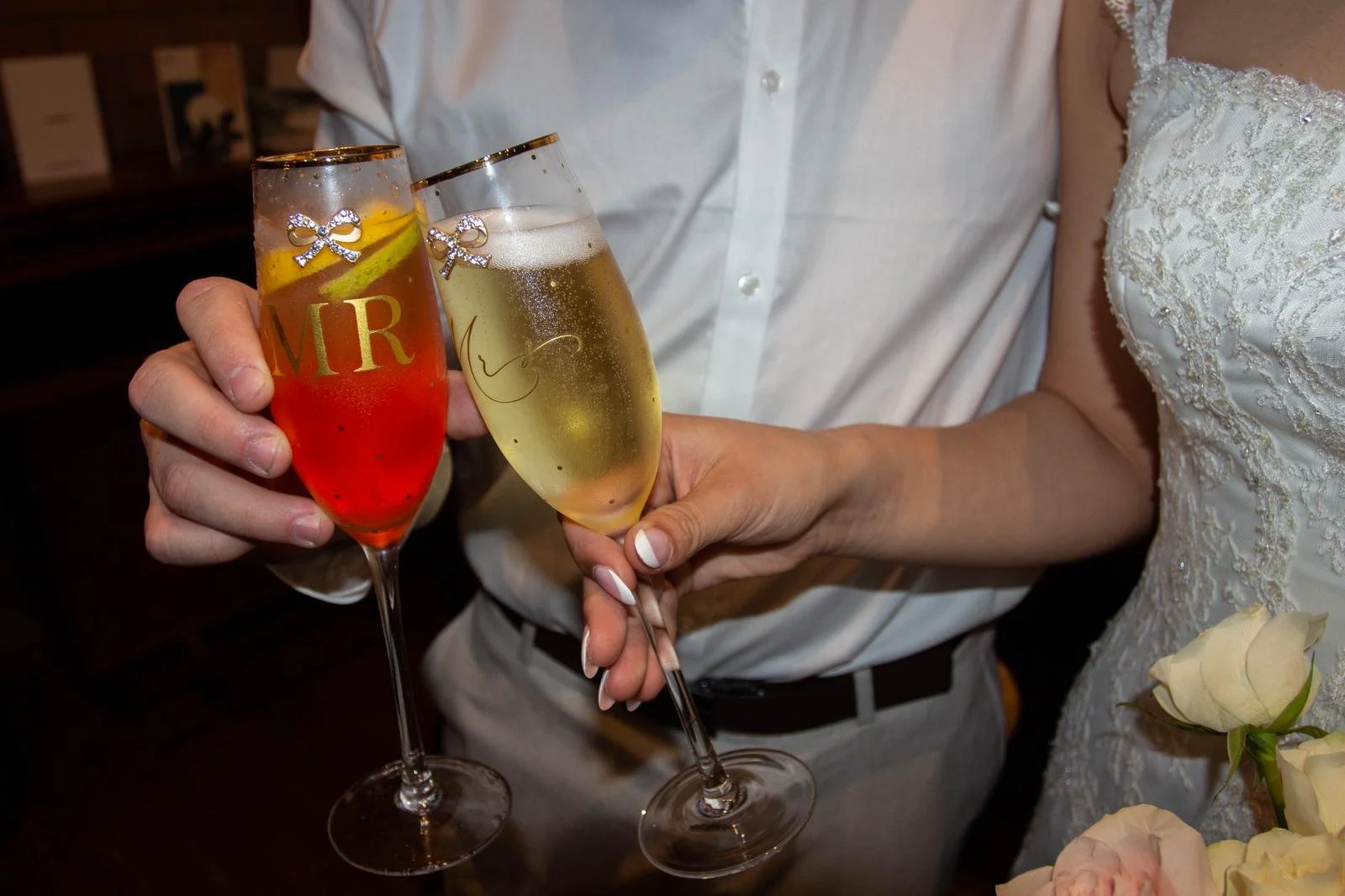 bride and groom holding mr and mrs champagne glasses