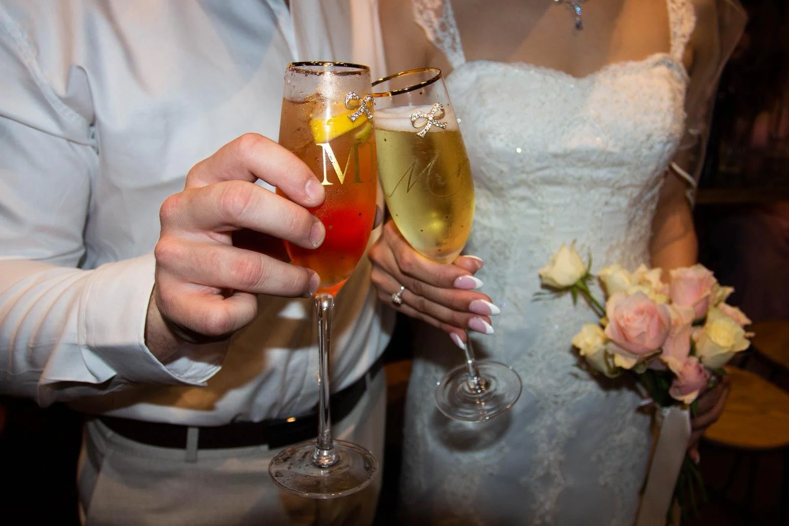 bride and groom holding mr and mrs champagne glasses