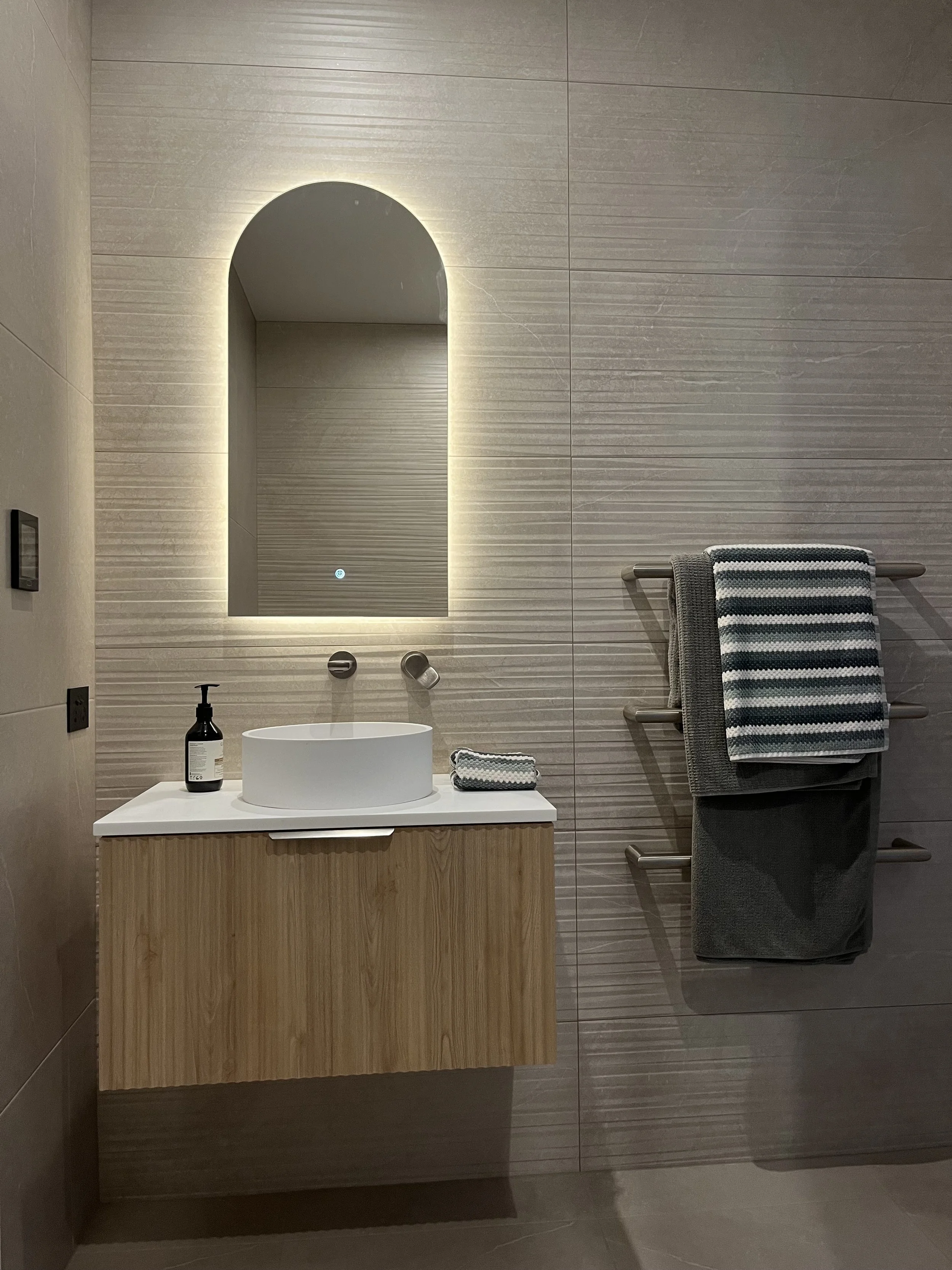 Back lit LED mirror above vanity, 3x heated towel rail bar on wall 