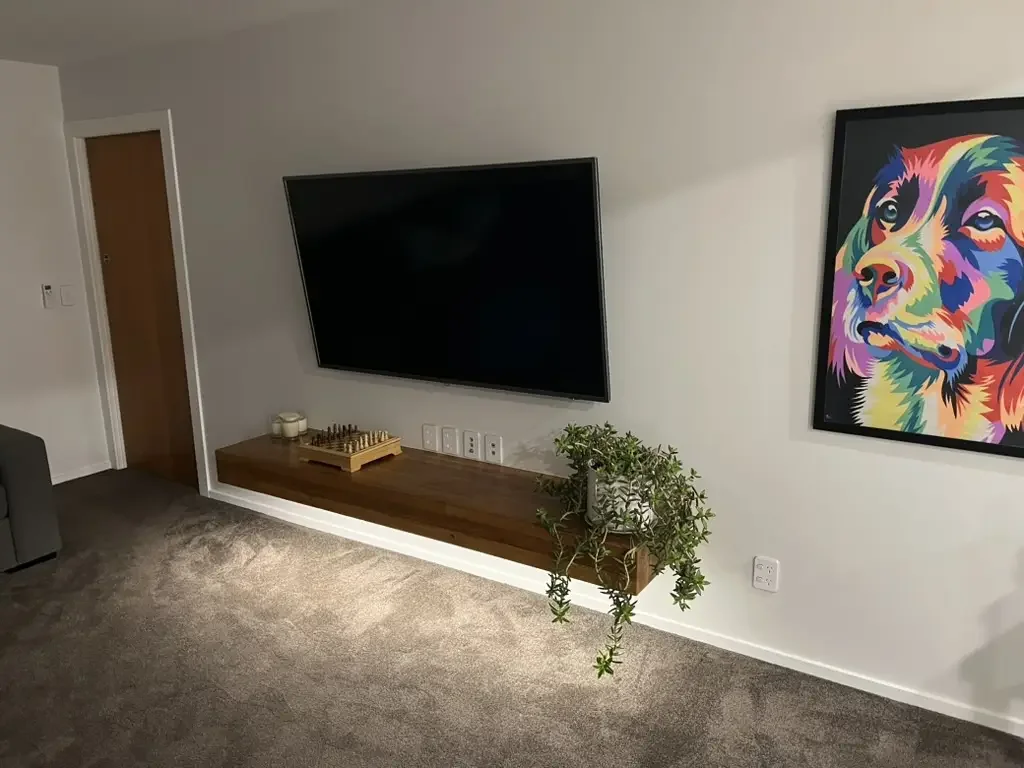Wall-mounted TV installation with concealed wiring and power outlets by residential electrician