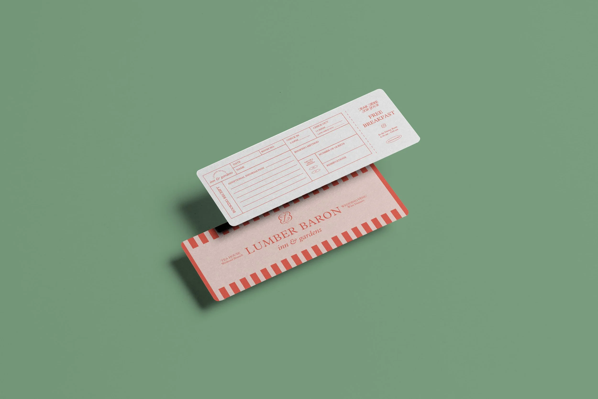 A pink and white striped card with the text 'LUMBER BARON inn & gardens' on it, and a white boarding pass above it on a green background.