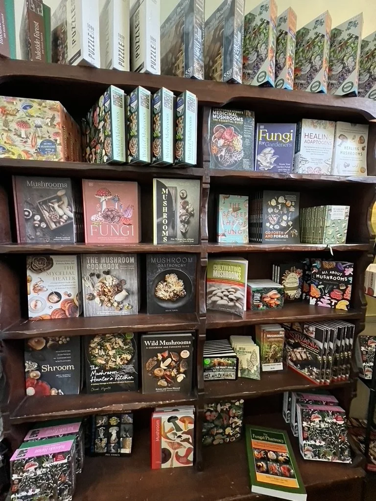 Bookcase filled with mushroom-themed books and jigsaw puzzles