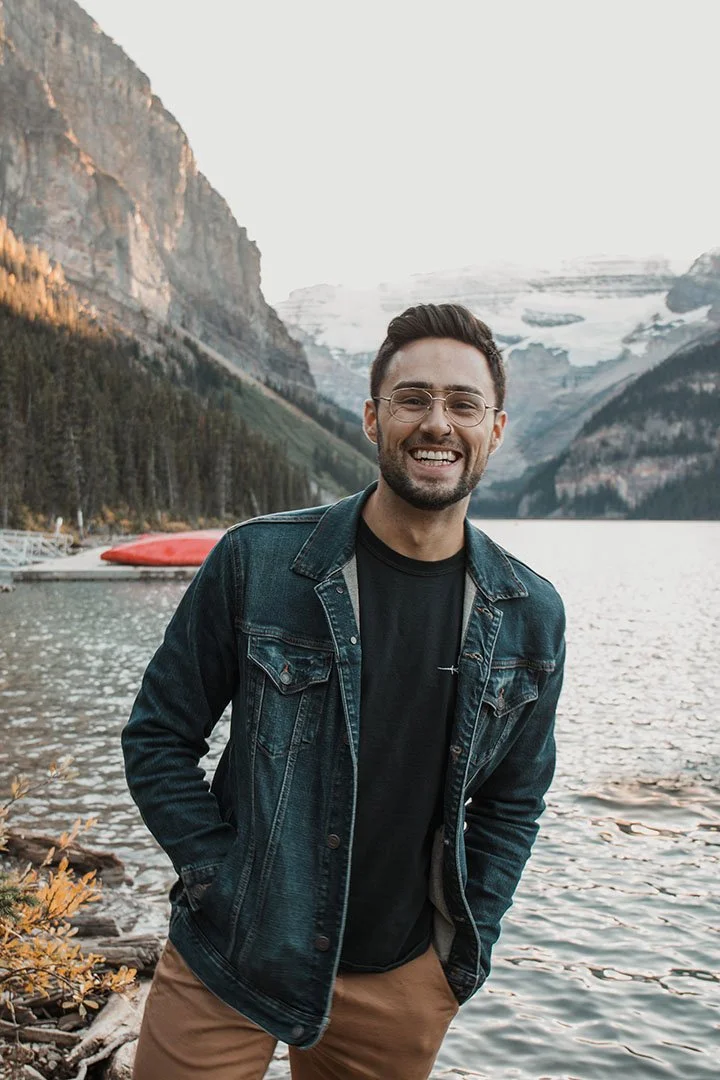 digital photograph of Ryan Maisey in front of water with mountains in the background