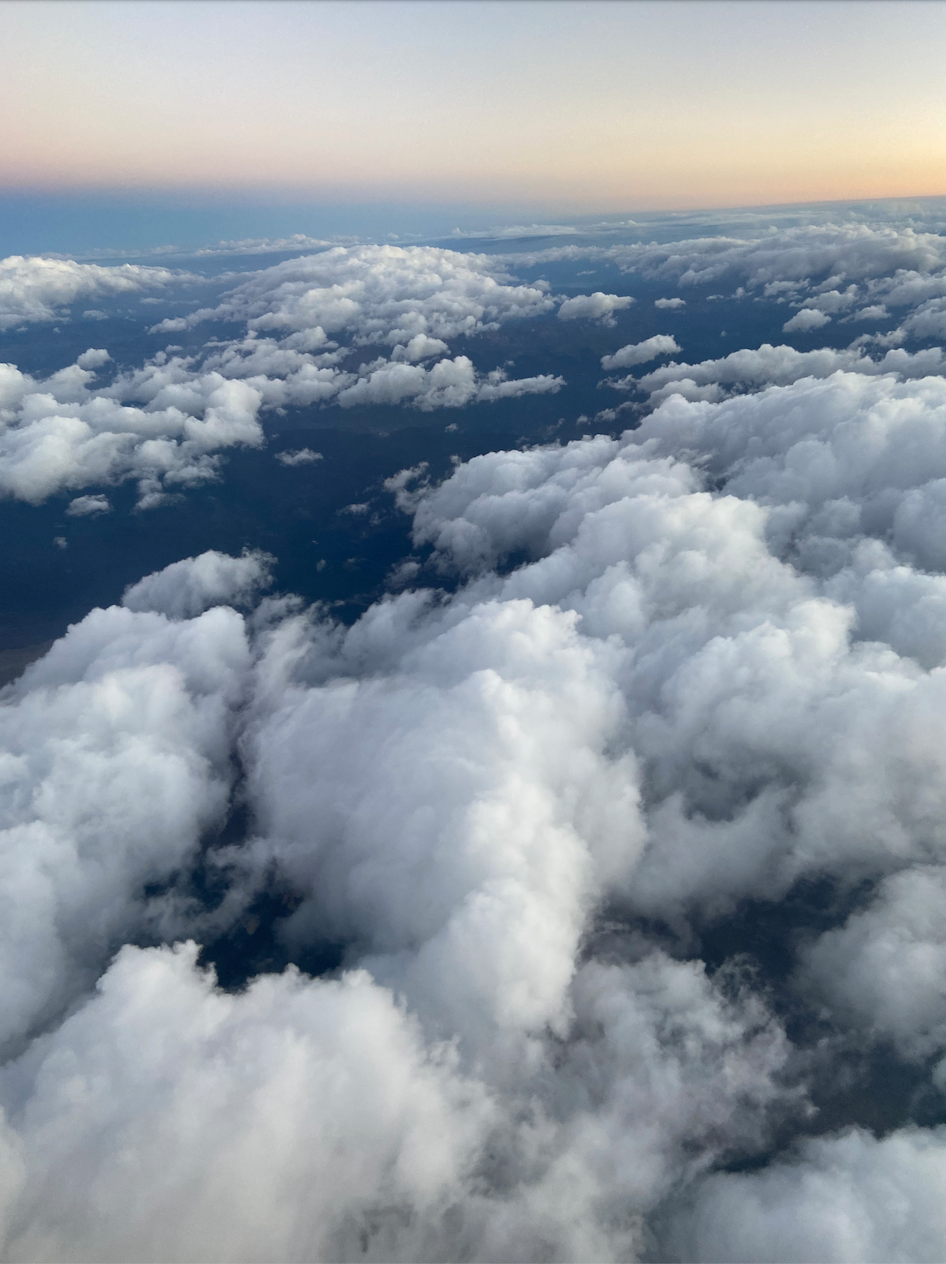 View of clouds from above the sky during sunset or sunrise.