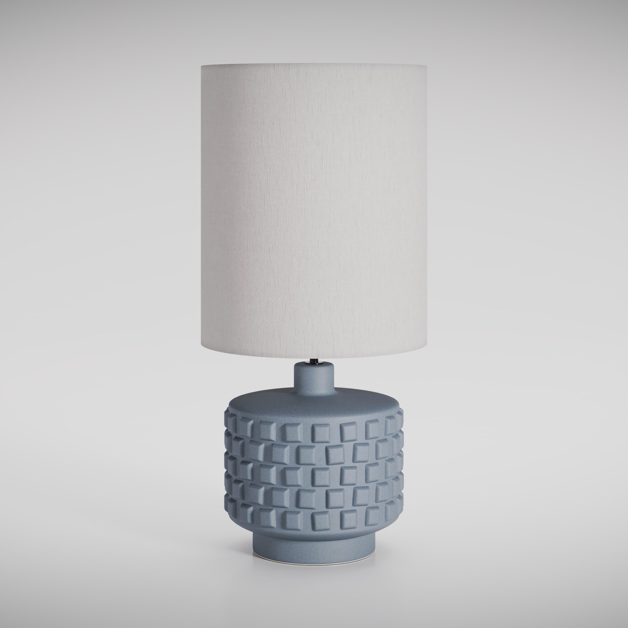 View of a modern type of table lamp with a fabric shade, in a white studio