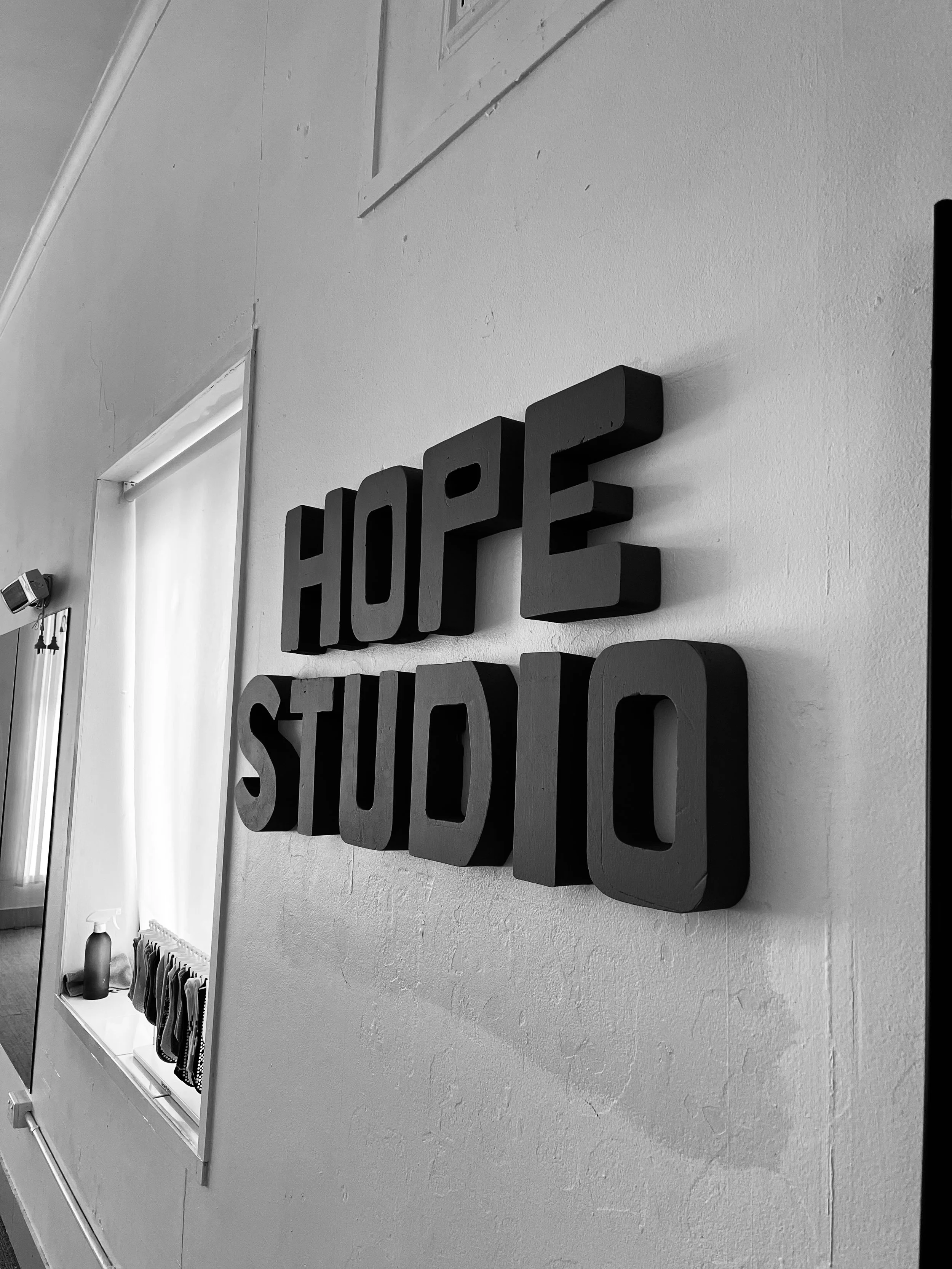 Black 3D letters on a wall spelling "HOPE STUDIO"