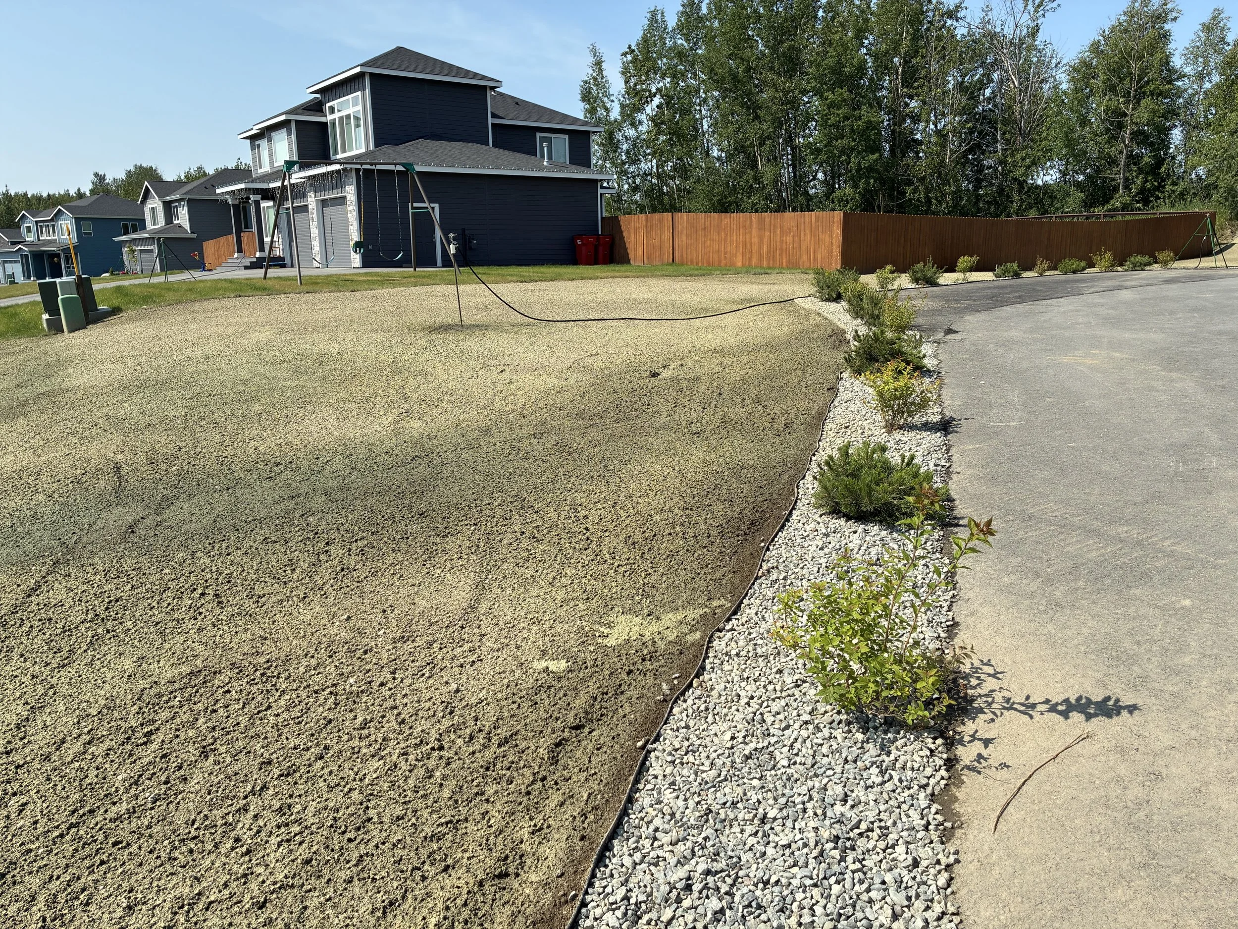 New construction home in Alaska with hydroseeded lawn and fresh landscaping.