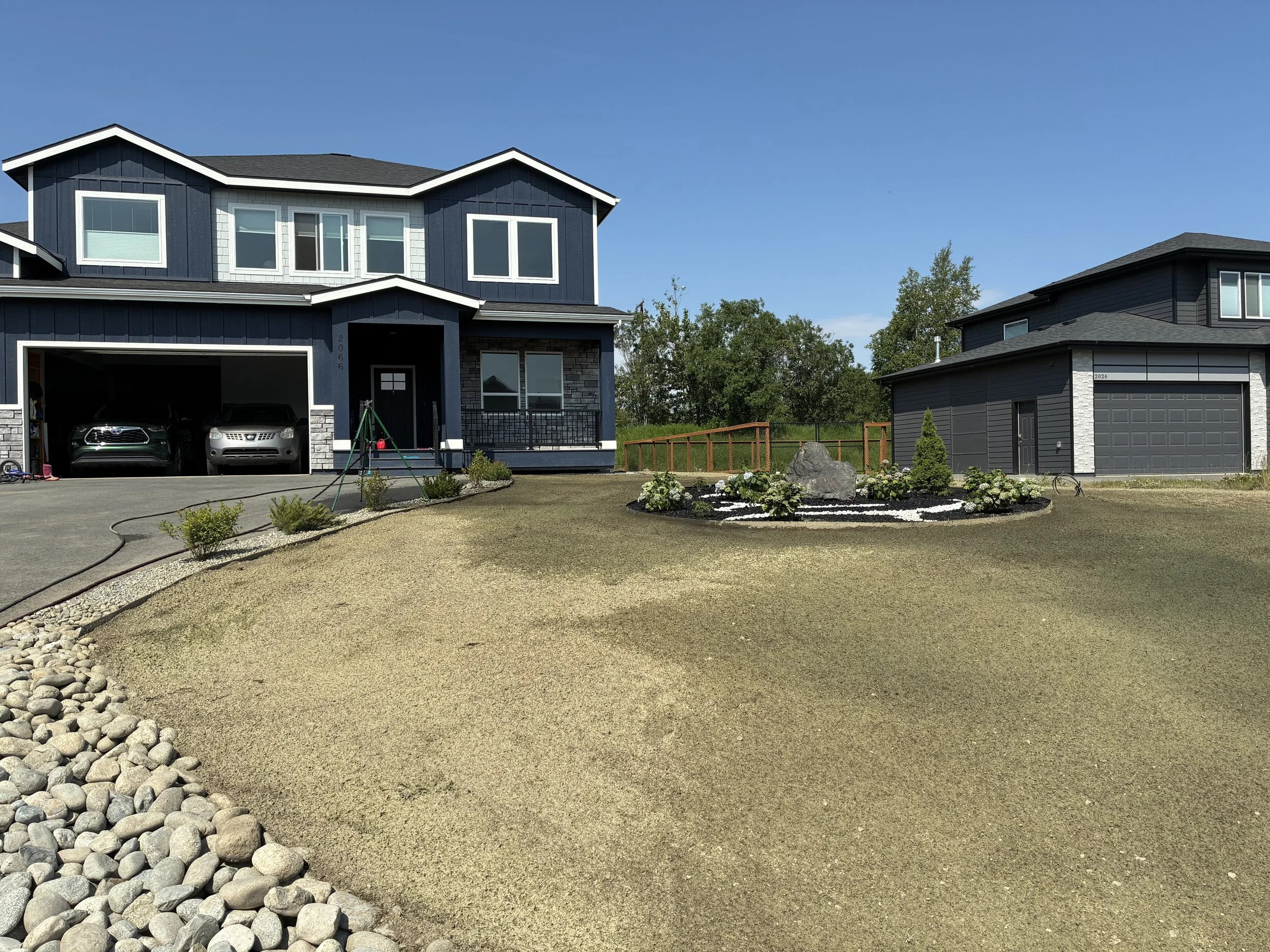 New construction home in Alaska with fresh landscaping and hydroseeded lawn.