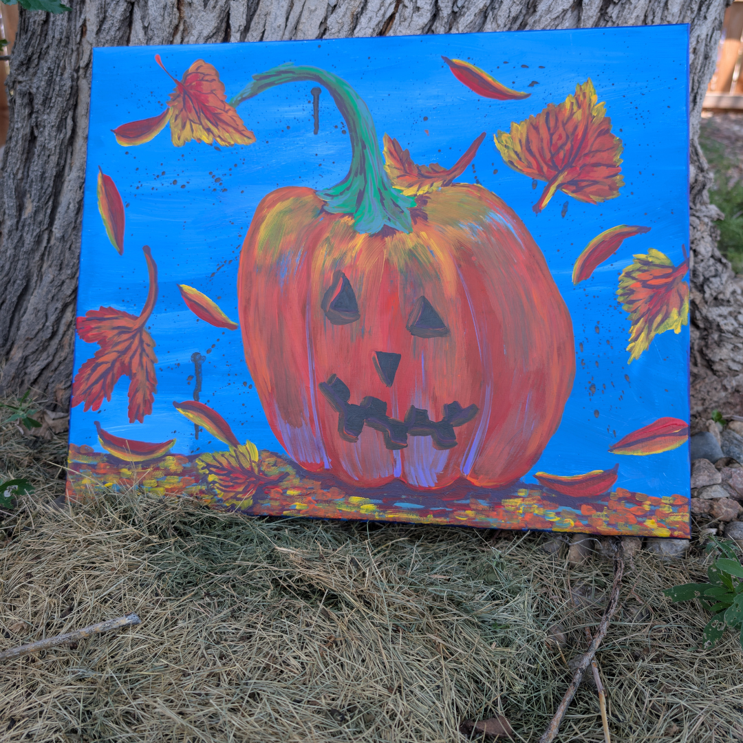 A bright, colorful painting of a jack-o'-lantern with a smiling face, surrounded by falling autumn leaves against a blue background, propped against a tree outdoors.