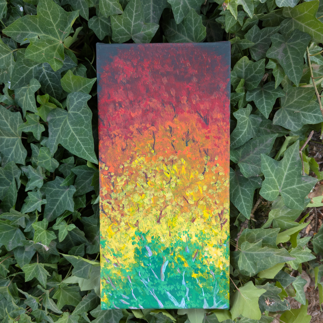 Colorful abstract painting with a gradient of colors from green at the bottom, through yellow, orange, red, and dark red at the top, surrounded by green ivy leaves.