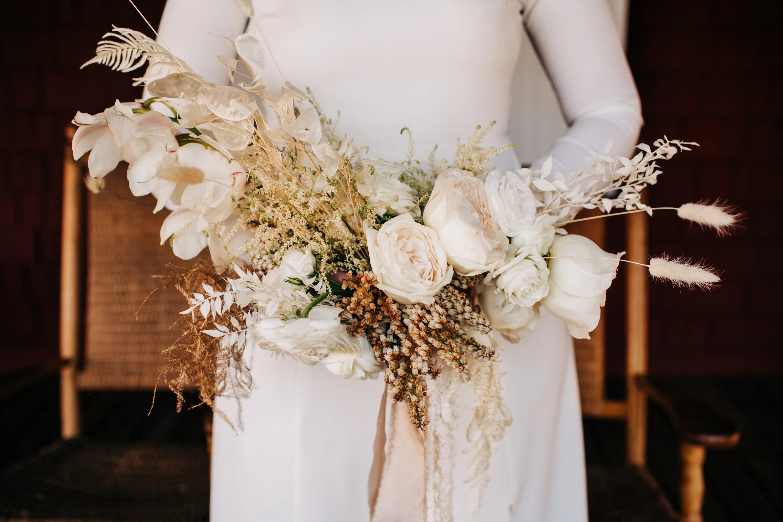 bride white floral bouquet with roses, peonies, and dried foliage