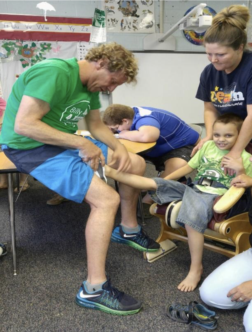 Billy Lerner helping a child with new shoes.