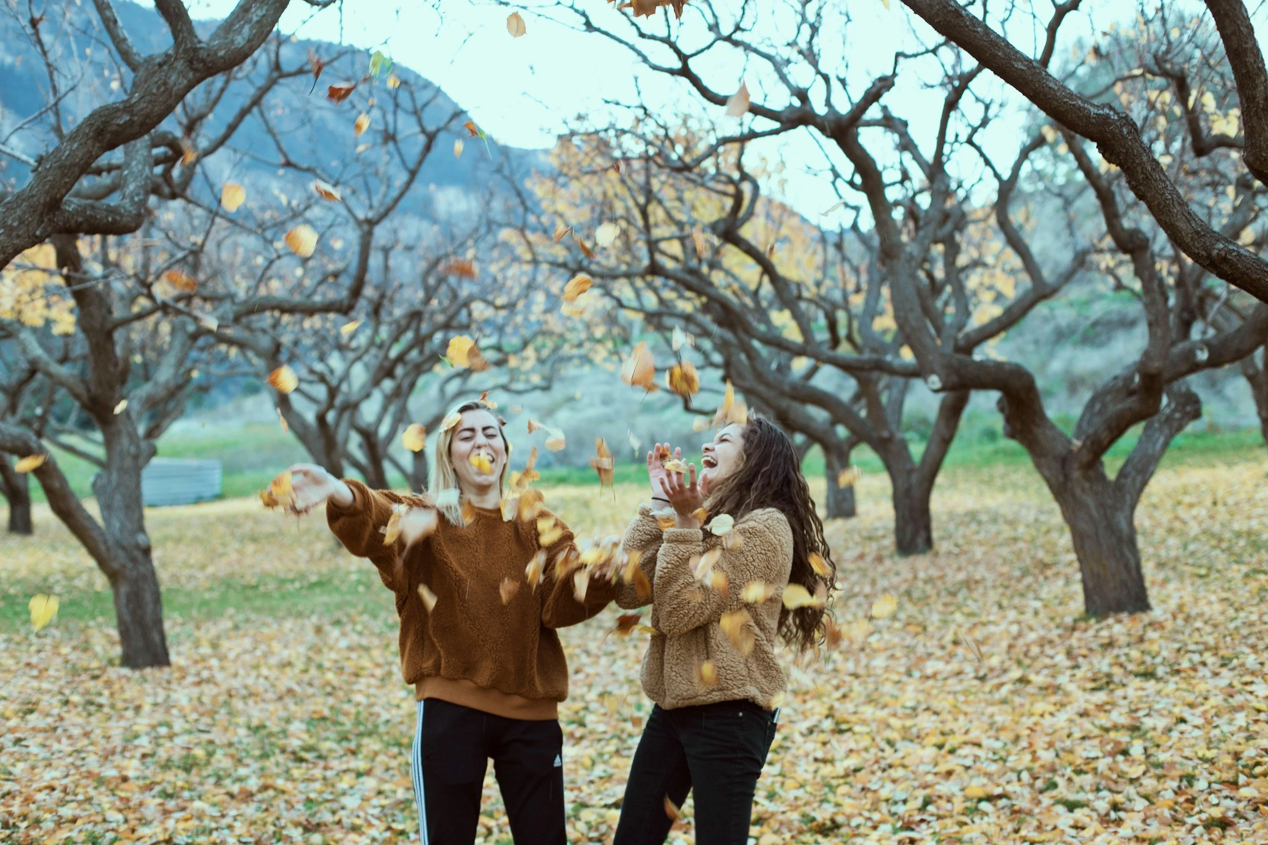 Lesbian couple in Michigan laughing and playing during the fall