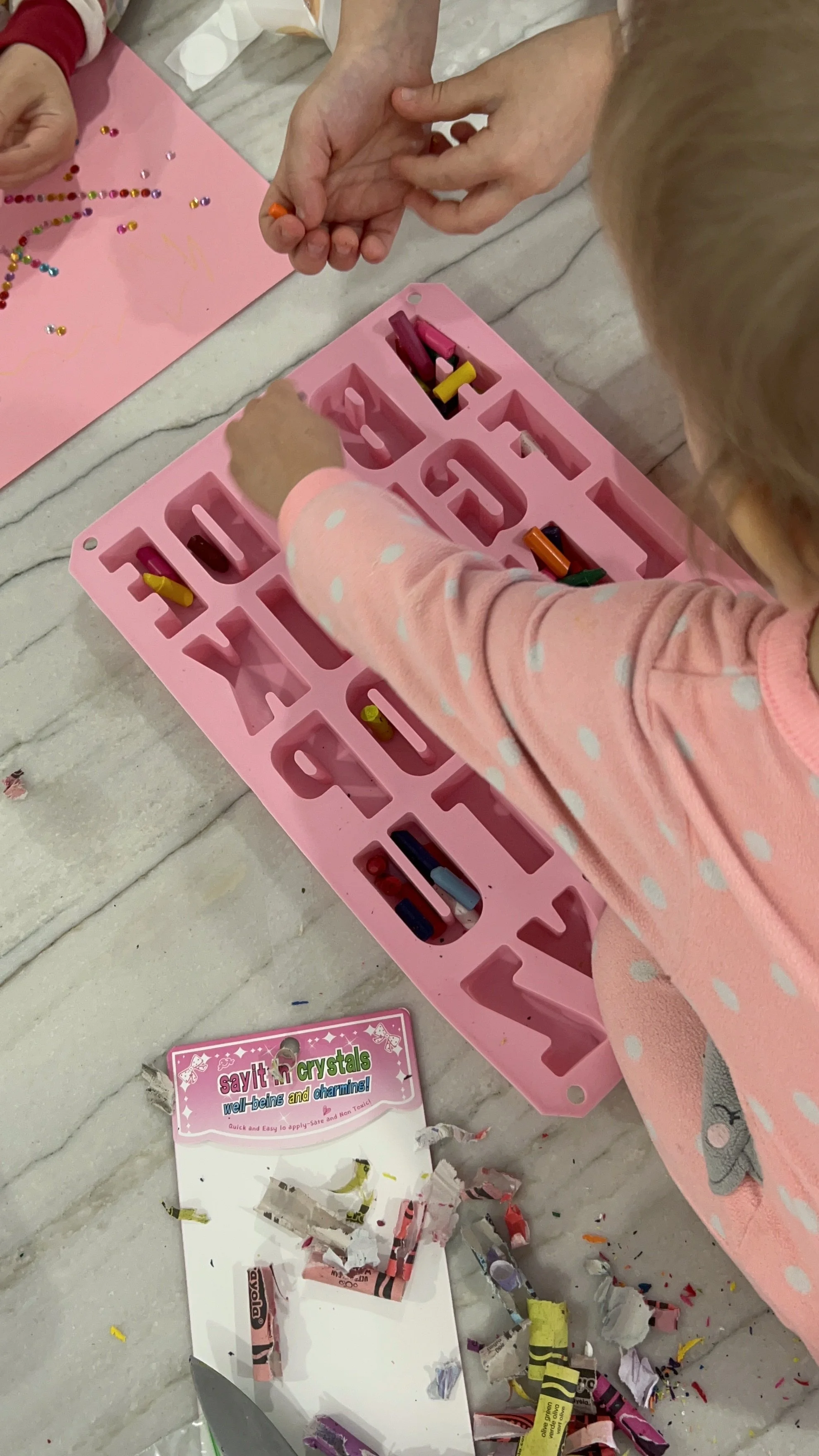 Picture of young children filling up silicone mold to make their own homemade crayons