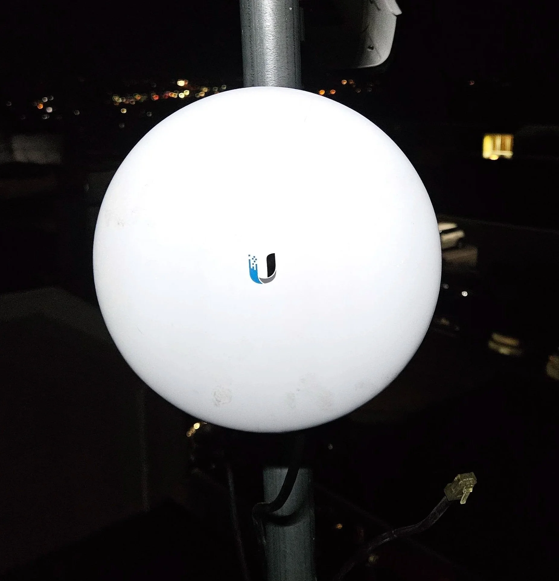 Outdoor Ubiquiti wireless radio mounted on a pole to provide reliable point-to-point network connectivity between buildings.