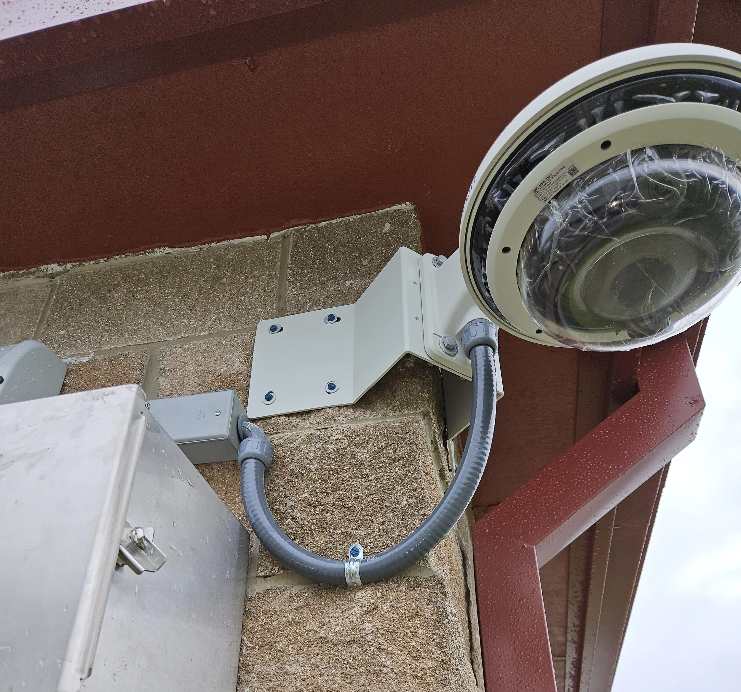 Commercial exterior security camera installation with a secure wall-mounted bracket and weatherproof conduit for a clean, protected finish.