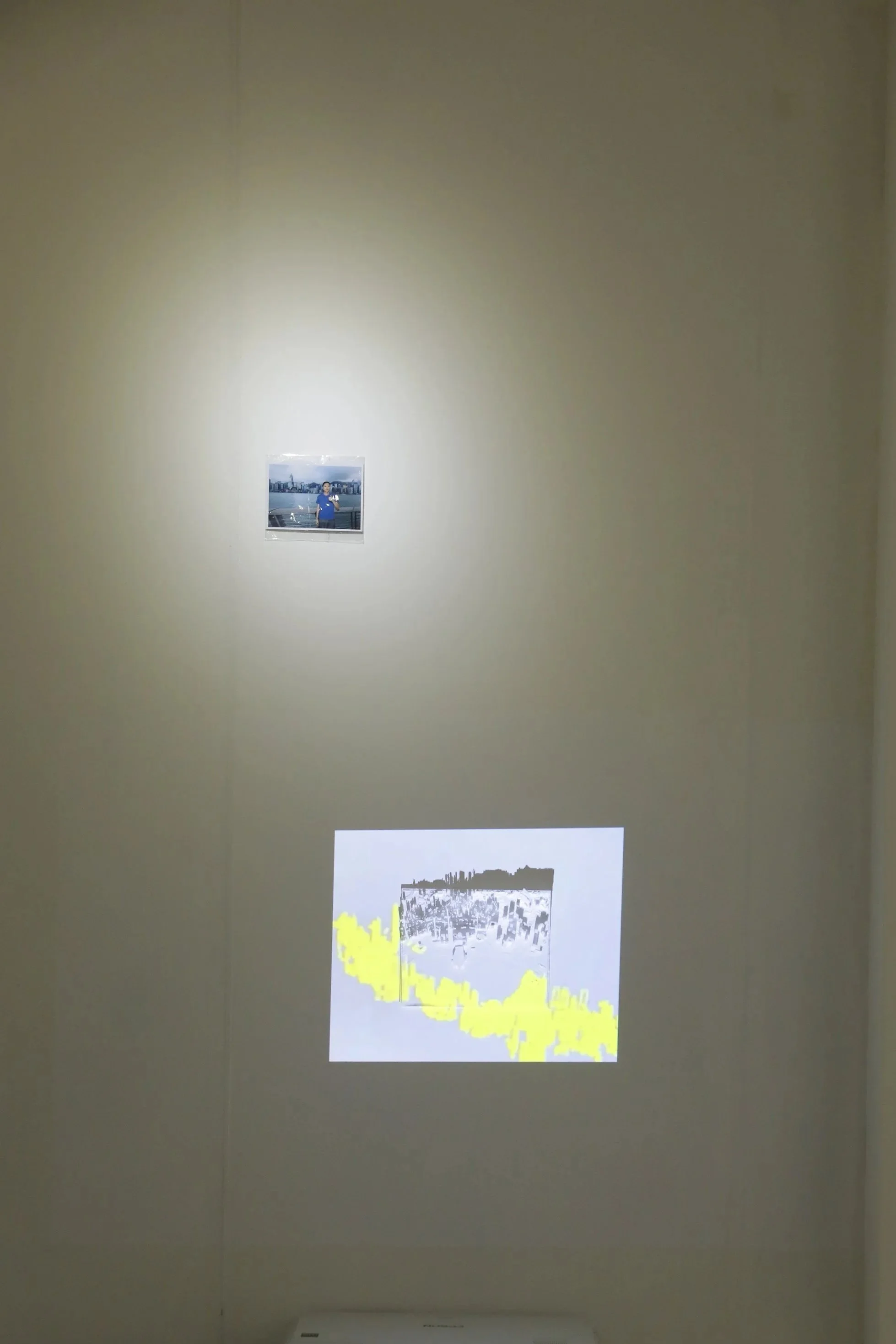 This is the work of Aidan Ng Ho Long, called '$50 Project'. A 3D printed model of Victoria Harbor mounted on wall, with video projections.