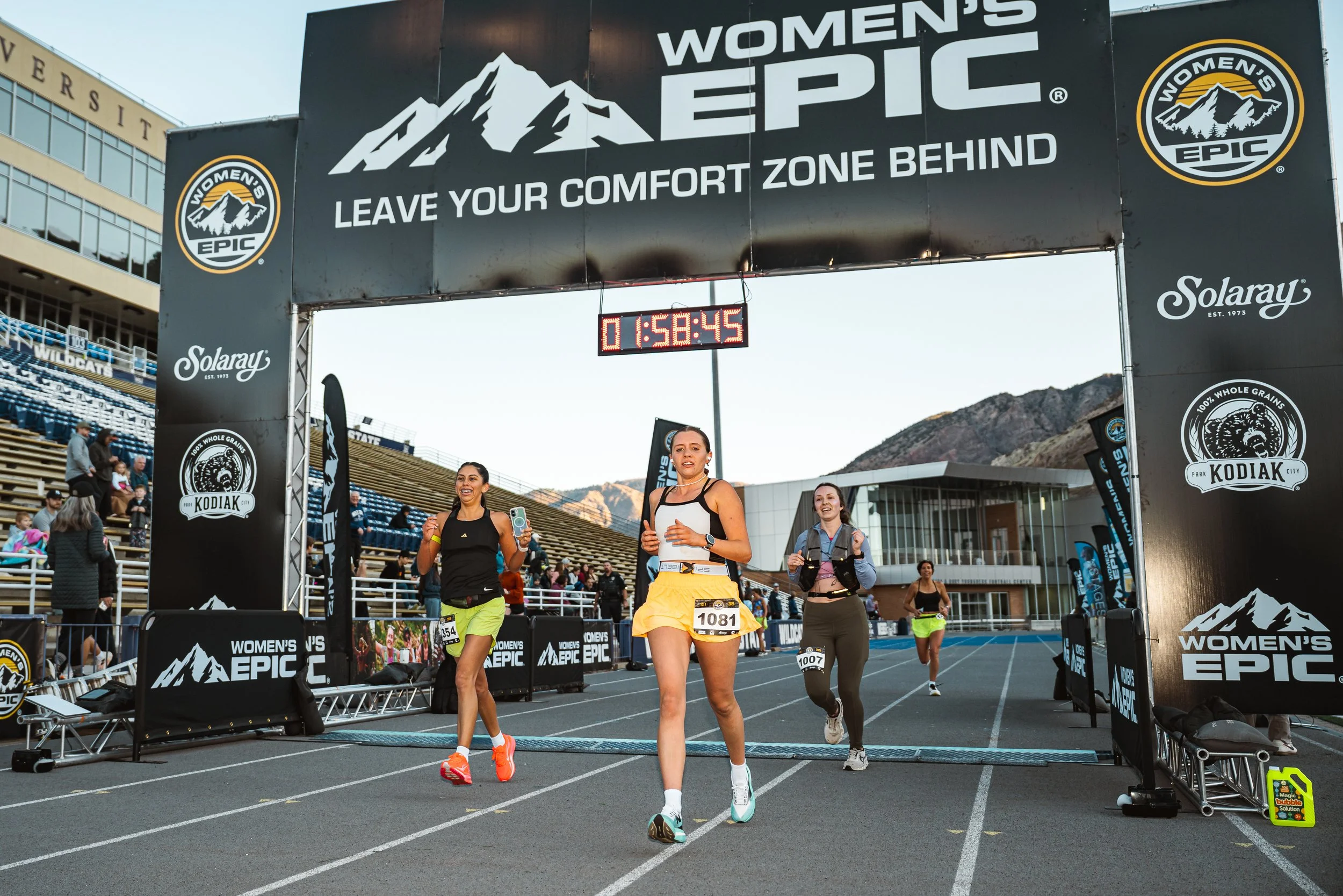 Three women in athletic attire smile and pose together for a photo, showcasing their camaraderie and sporty spirit
