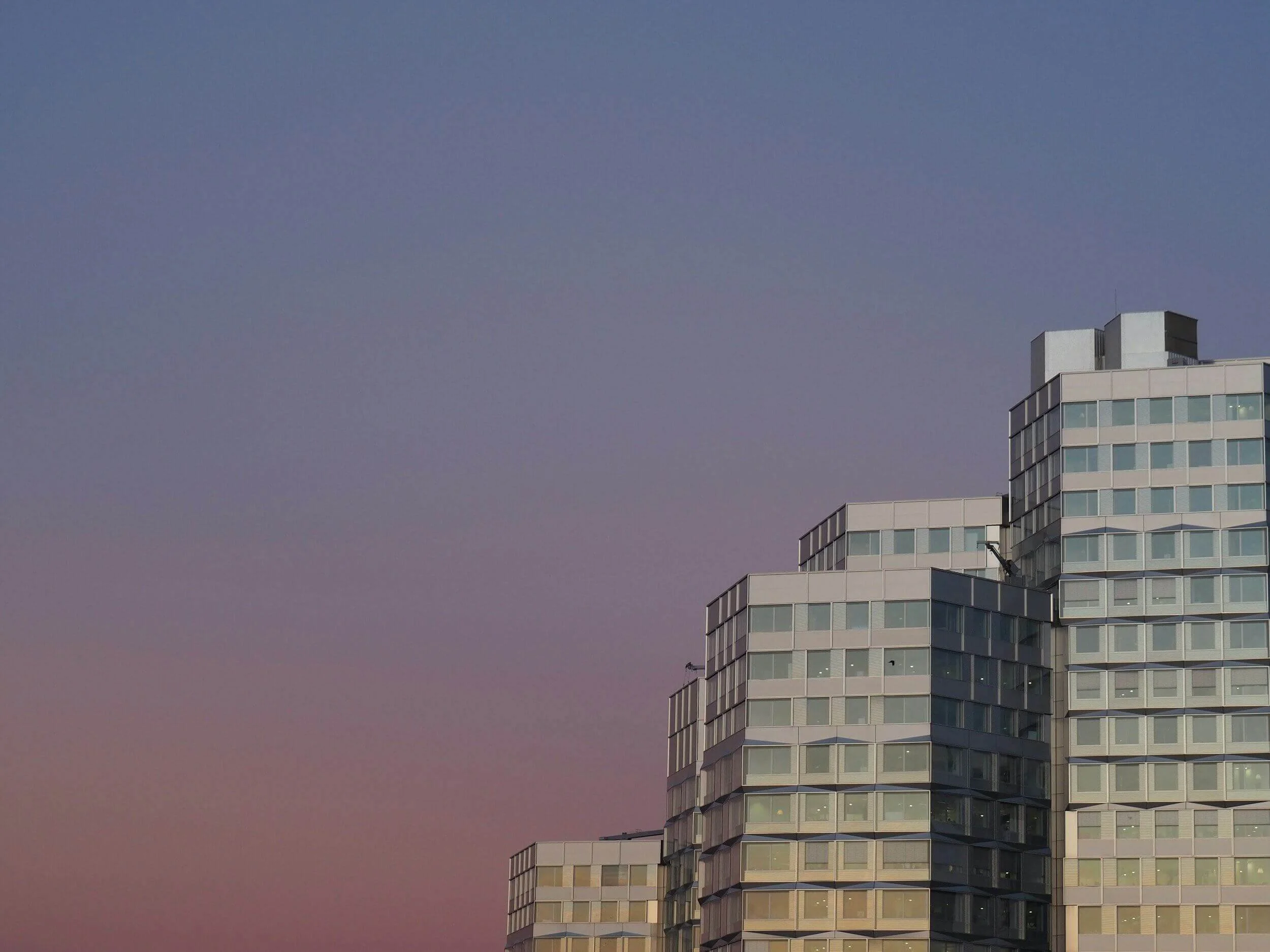 Vue des bâtiments modernes à Boulogne-Billancourt, avec un ciel crépusculaire coloré. Idéal pour découvrir notre agence et ses services d’essayage dans cette ville cosmopolite et dynamique.