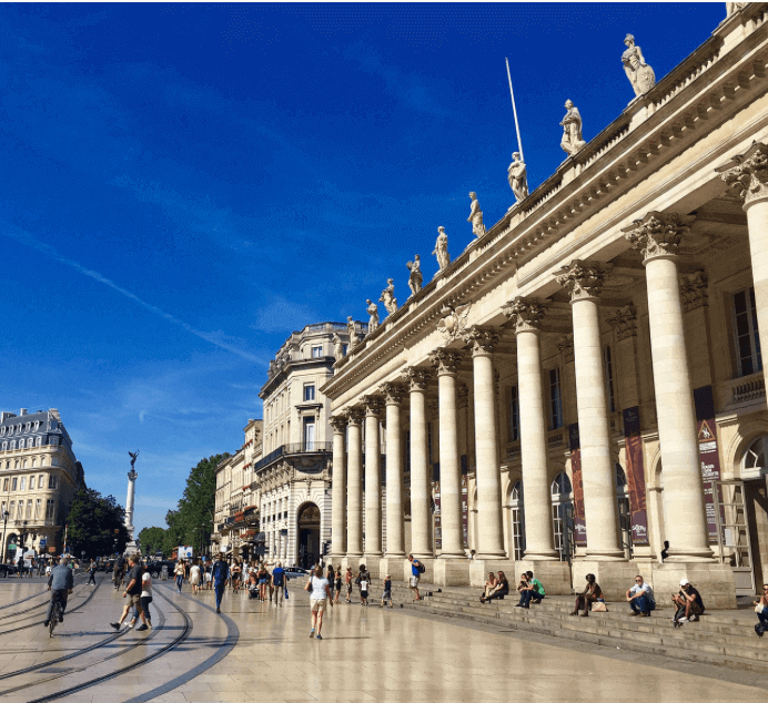 Vue panoramique de la Place du Grand Théâtre à Bordeaux, avec ses colonnes majestueuses et une ambiance animée. Idéal pour découvrir comment devenir mannequin d’essayage dans cette ville dynamique et culturelle.
