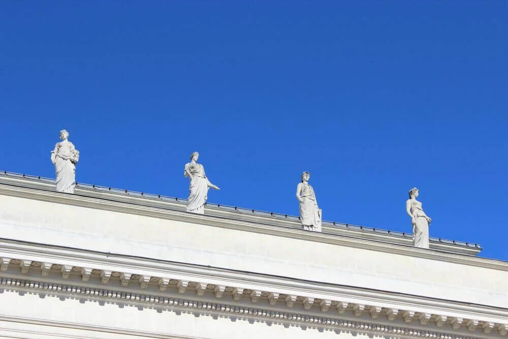 Vue d’un édifice historique à Nantes, orné de statues blanches majestueuses sur son fronton. Idéal pour découvrir comment devenir mannequin d’essayage à Nantes, une ville où l’architecture classique rencontre la modernité urbaine.