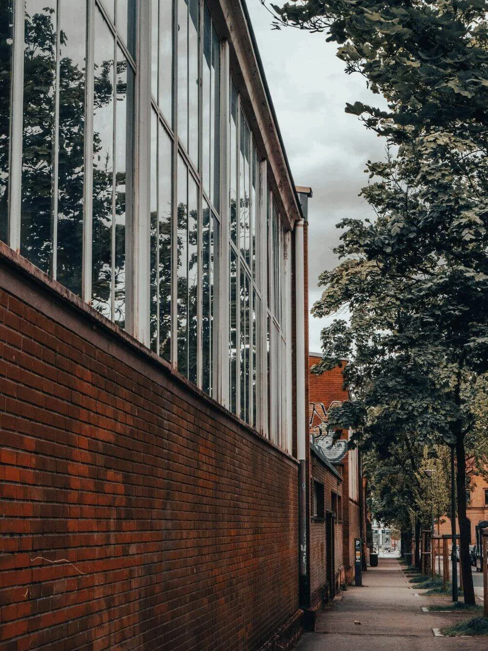 Vue d’une rue piétonne à Metz, bordée de bâtiments modernes et d’arbres verdoyants. Idéal pour découvrir comment devenir mannequin d’essayage à Metz, une ville où l’architecture contemporaine côtoie la nature.