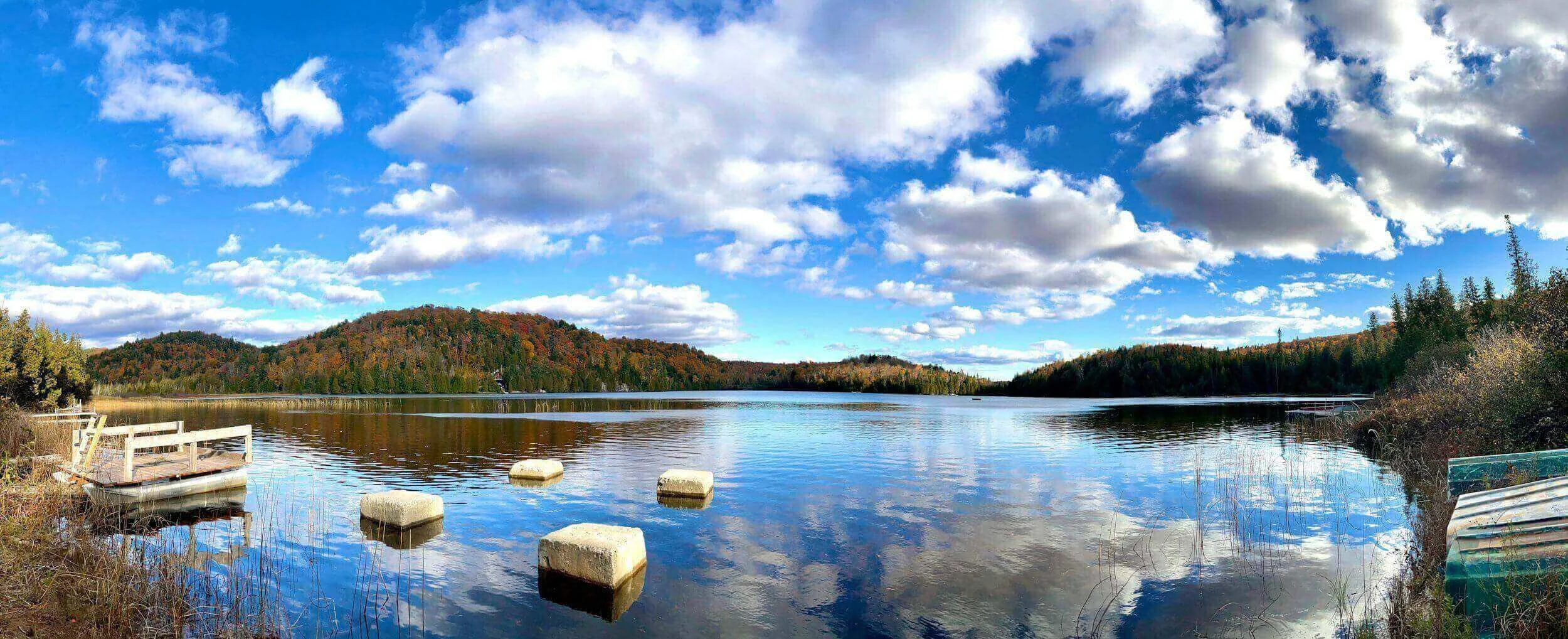 Vue panoramique d’un lac paisible à Argenteuil, entouré de forêts et reflétant un ciel bleu clair. Idéal pour découvrir notre agence et ses services d’essayage dans cette ville accueillante et naturelle.