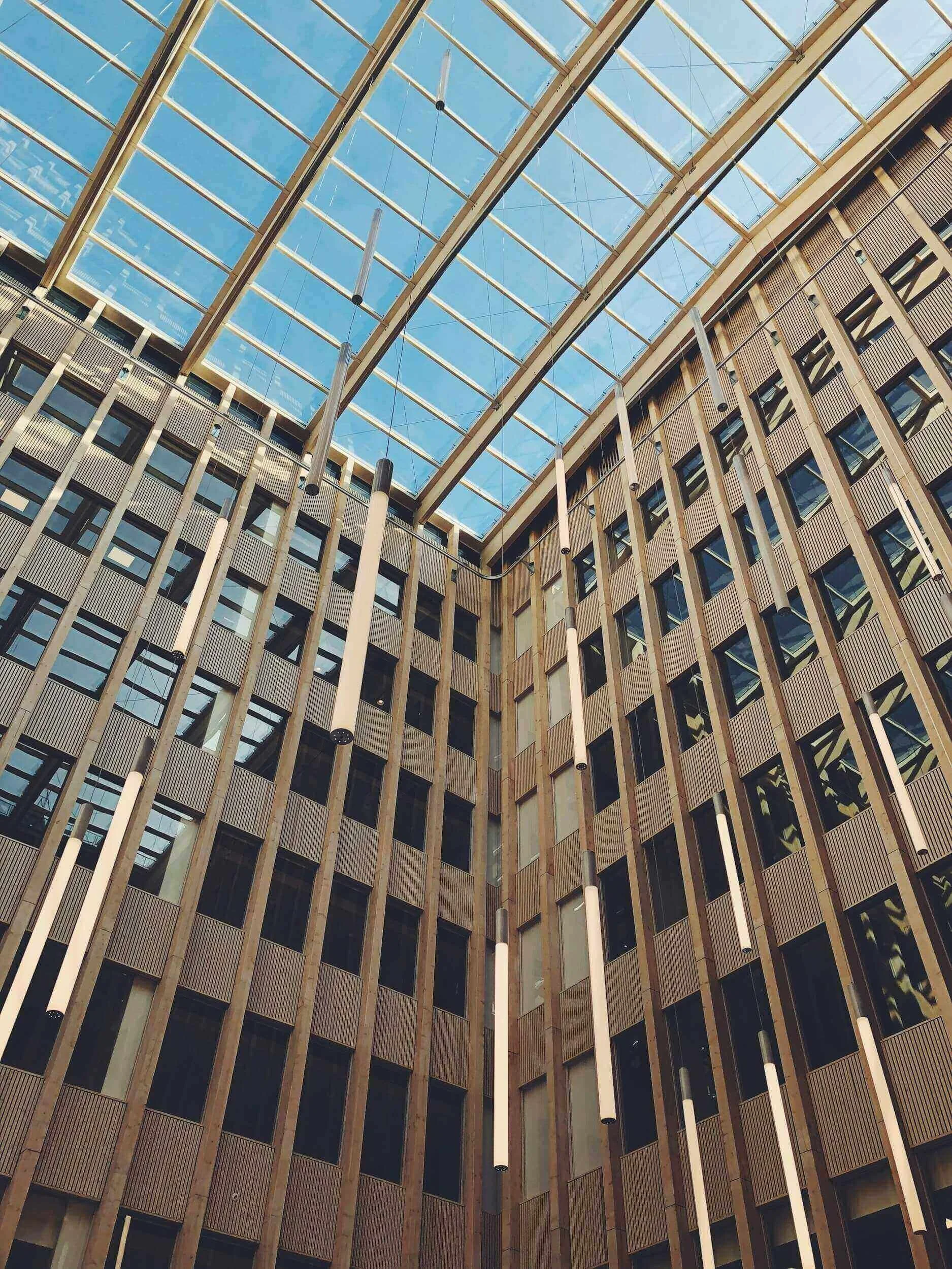 Vue intérieure d’un bâtiment moderne à Saint-Denis, avec une structure métallique et des fenêtres panoramiques laissant entrer la lumière naturelle. Idéal pour découvrir notre agence et ses services d’essayage.
