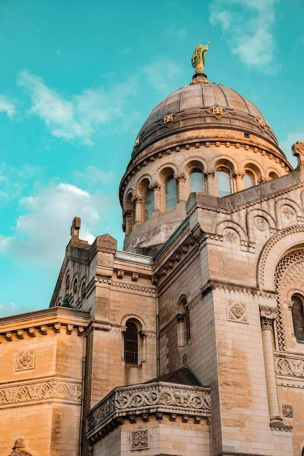 Vue majestueuse du dôme de la Basilique Saint-Martin à Tours, orné de détails architecturaux et surmonté d’une statue dorée. Idéal pour découvrir comment devenir mannequin d’essayage à Tours.