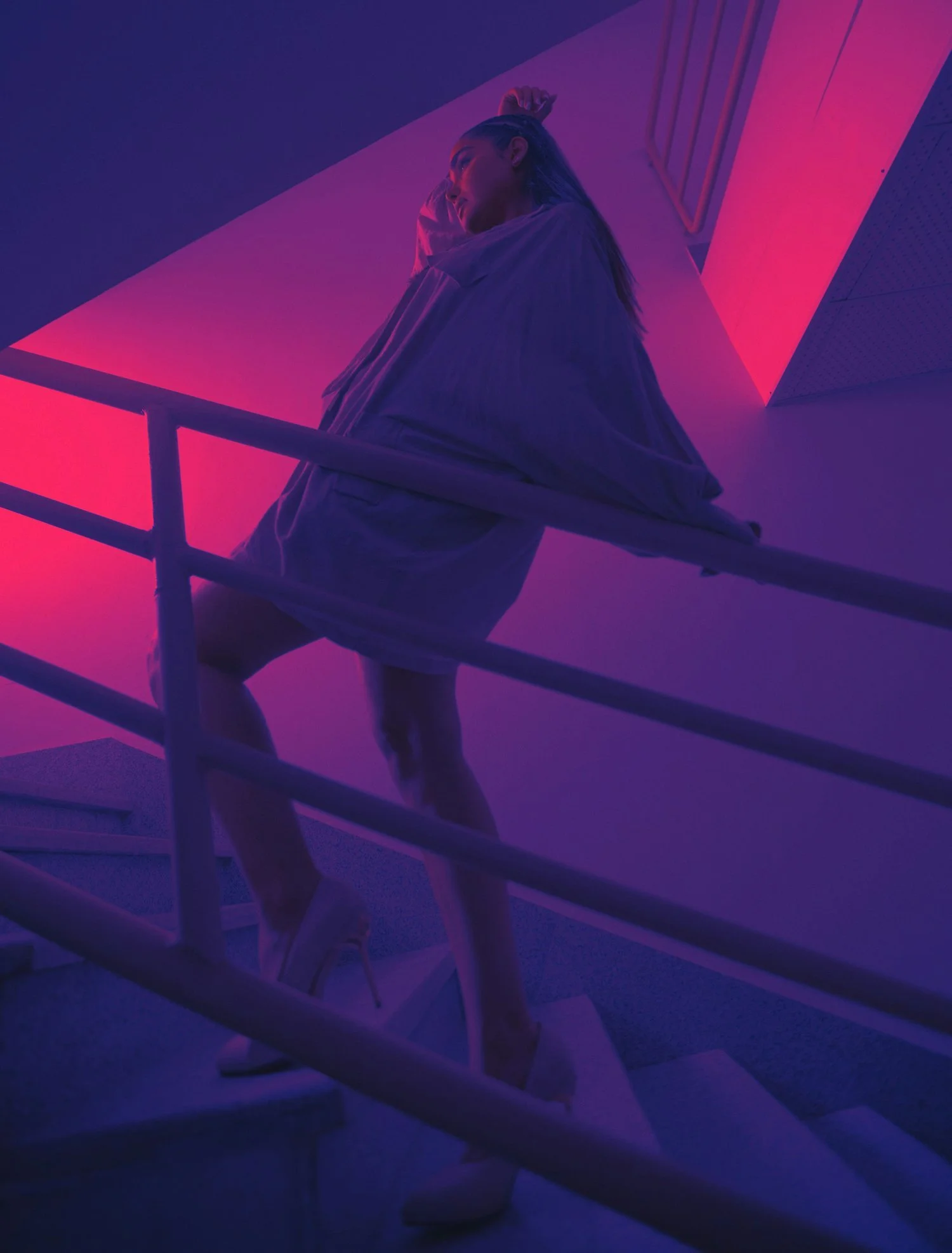 Dans cet article intitulé, The Casting Fit explore les compétences nécessaires pour réussir dans ce domaine. L’image montre une femme posant sur un escalier éclairé par des néons violets et roses, symbolisant la polyvalence et le professionnalisme.