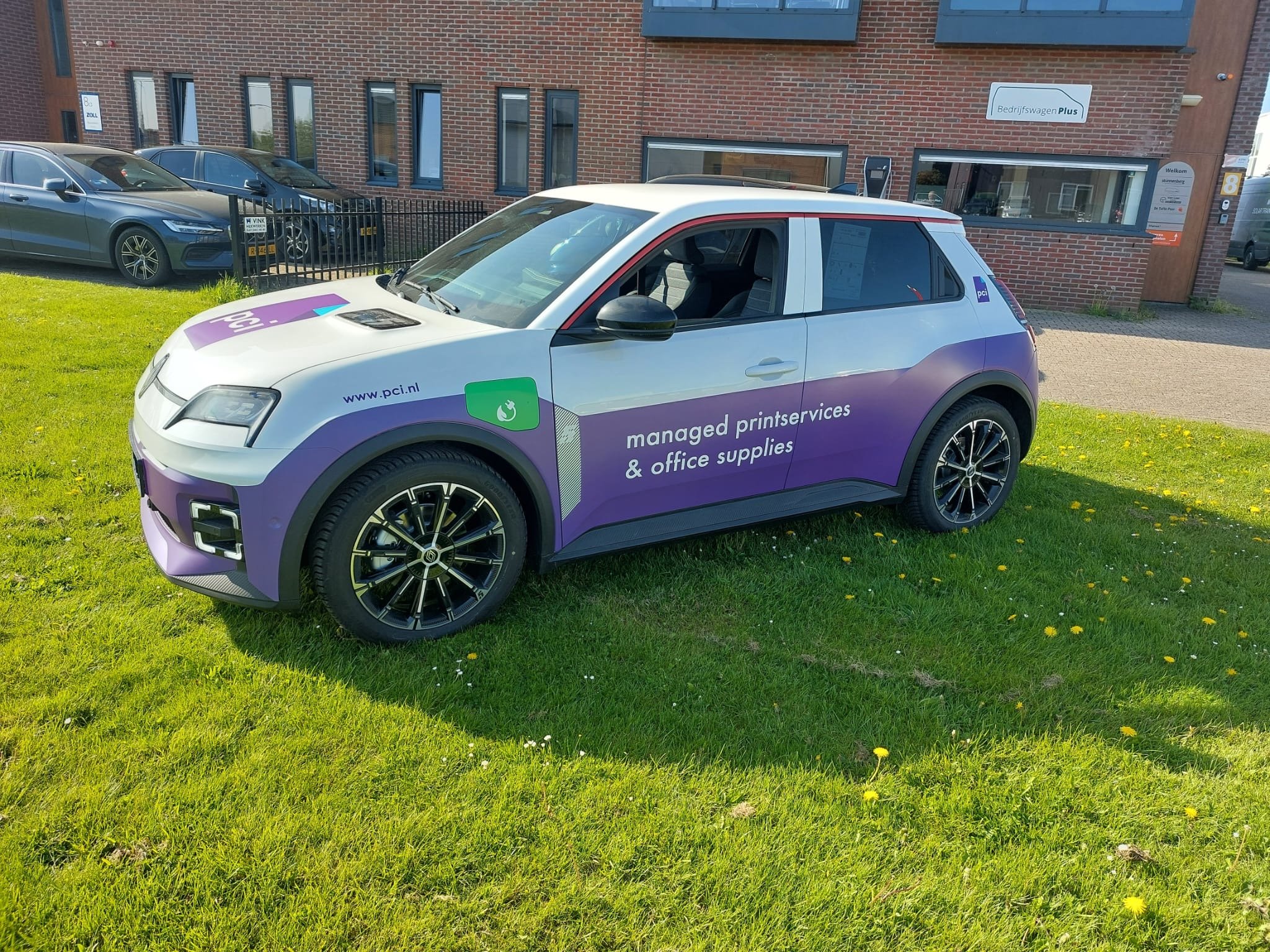 Een witte bedrijfswagen met de tekst 'A&D POST' en logo, aanwezig in een showroom met andere auto's, bedoeld voor spoedtransport, post en pakketten, opslag.