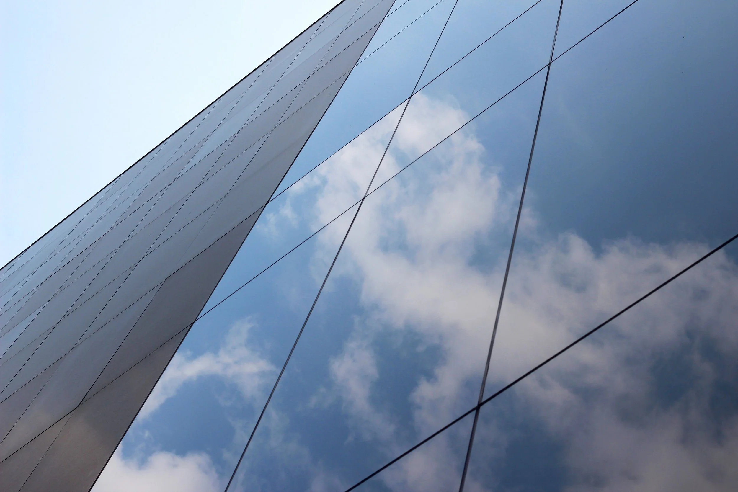 low-angle-shot-glass-high-rise-business-building-with-reflection-clouds-sky-it.jpg