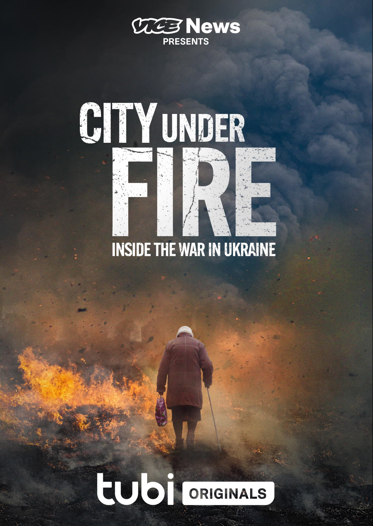 A woman walking with a cane through a war-torn landscape with fire and smoke, promoting the Vice News series 'City Under Fire: Inside the War in Ukraine' on Tubi Originals.
