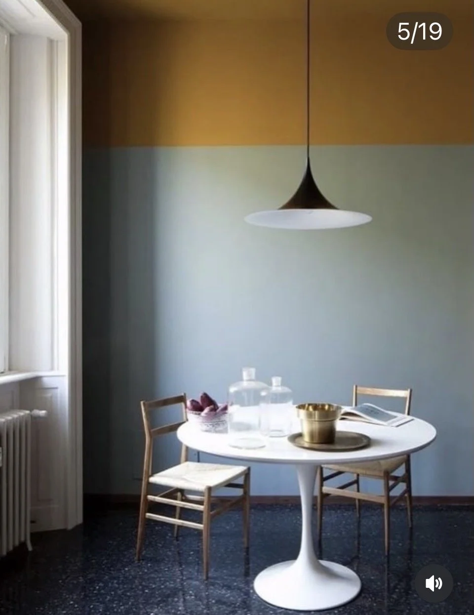 Pièce lumineuse avec murs colorés, table ronde et ambiance magazine