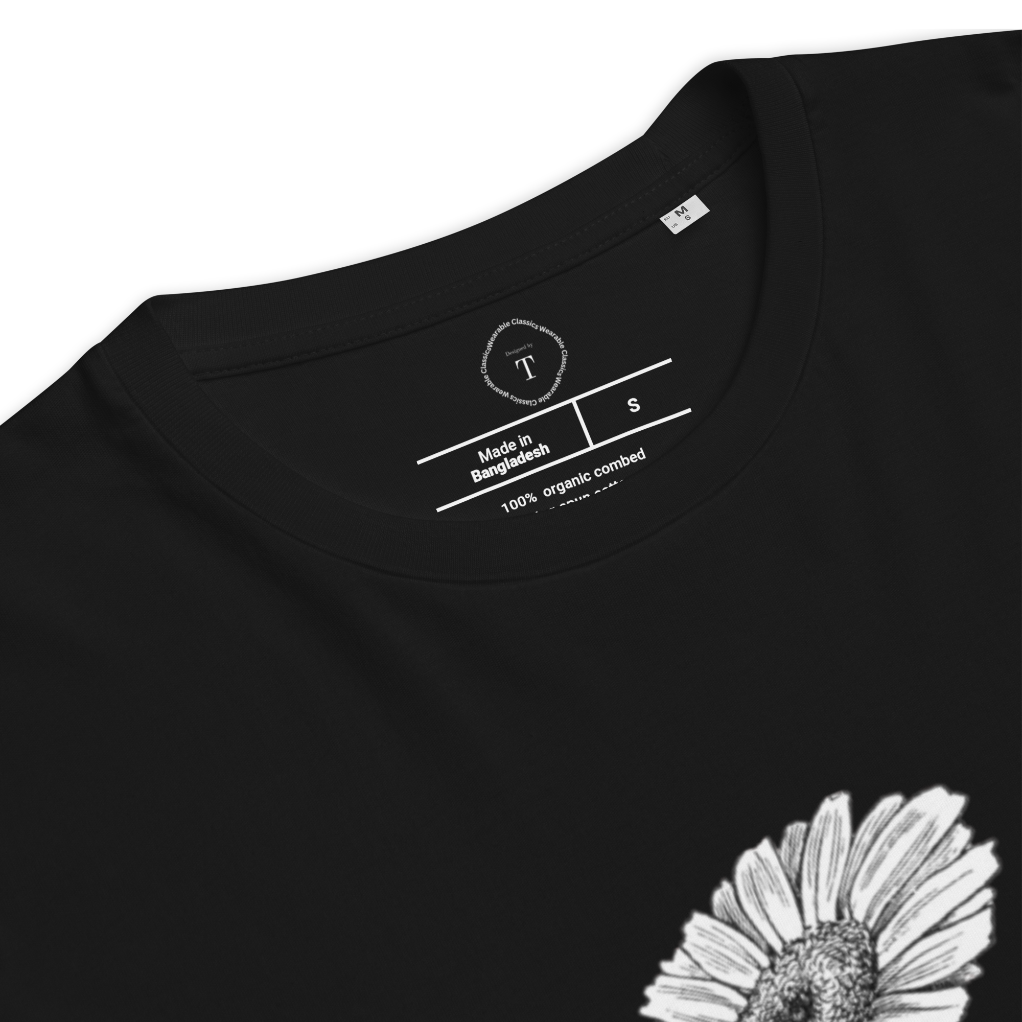 Black Unisex Cotton T-Shirt folded close up with black and white image of daisy flower in the centre