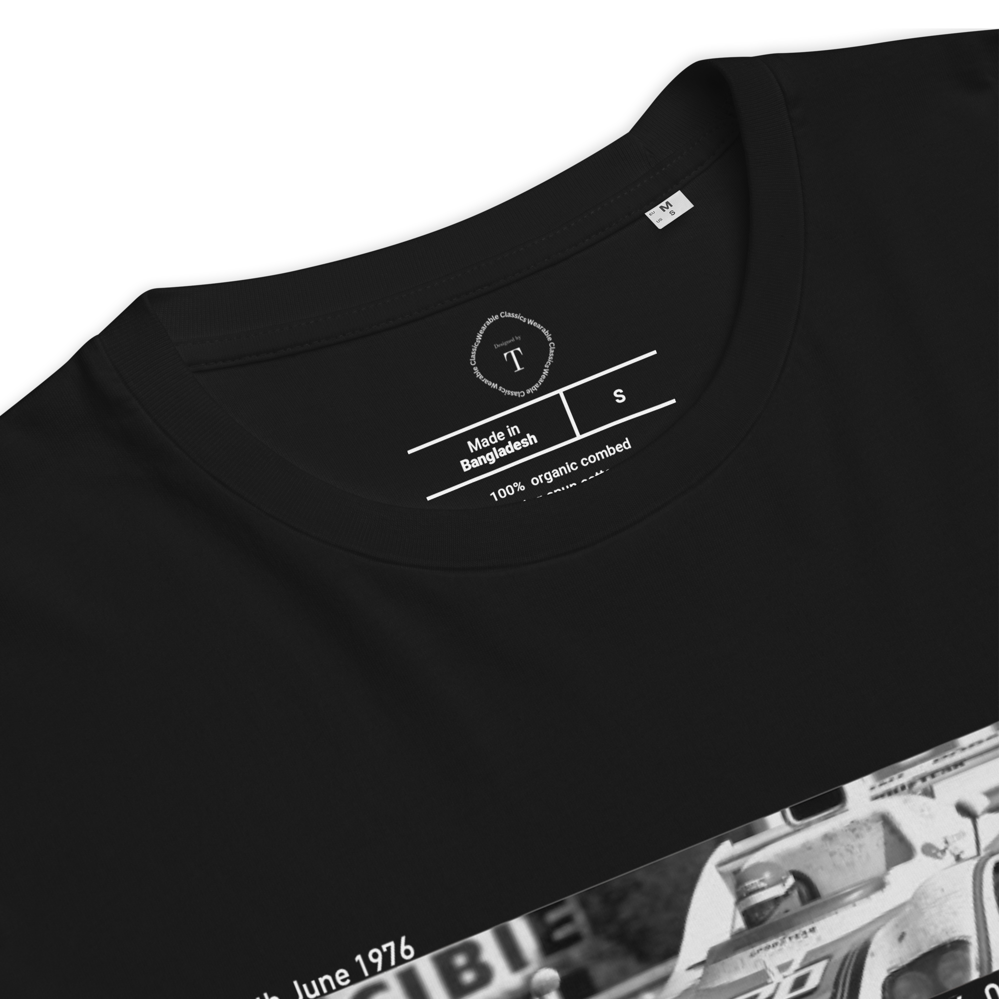 Black Unisex Cotton T-Shirt folded close up with banner image of Porsche 1976 at Le Mans in the centre with text of coordinates and date of race