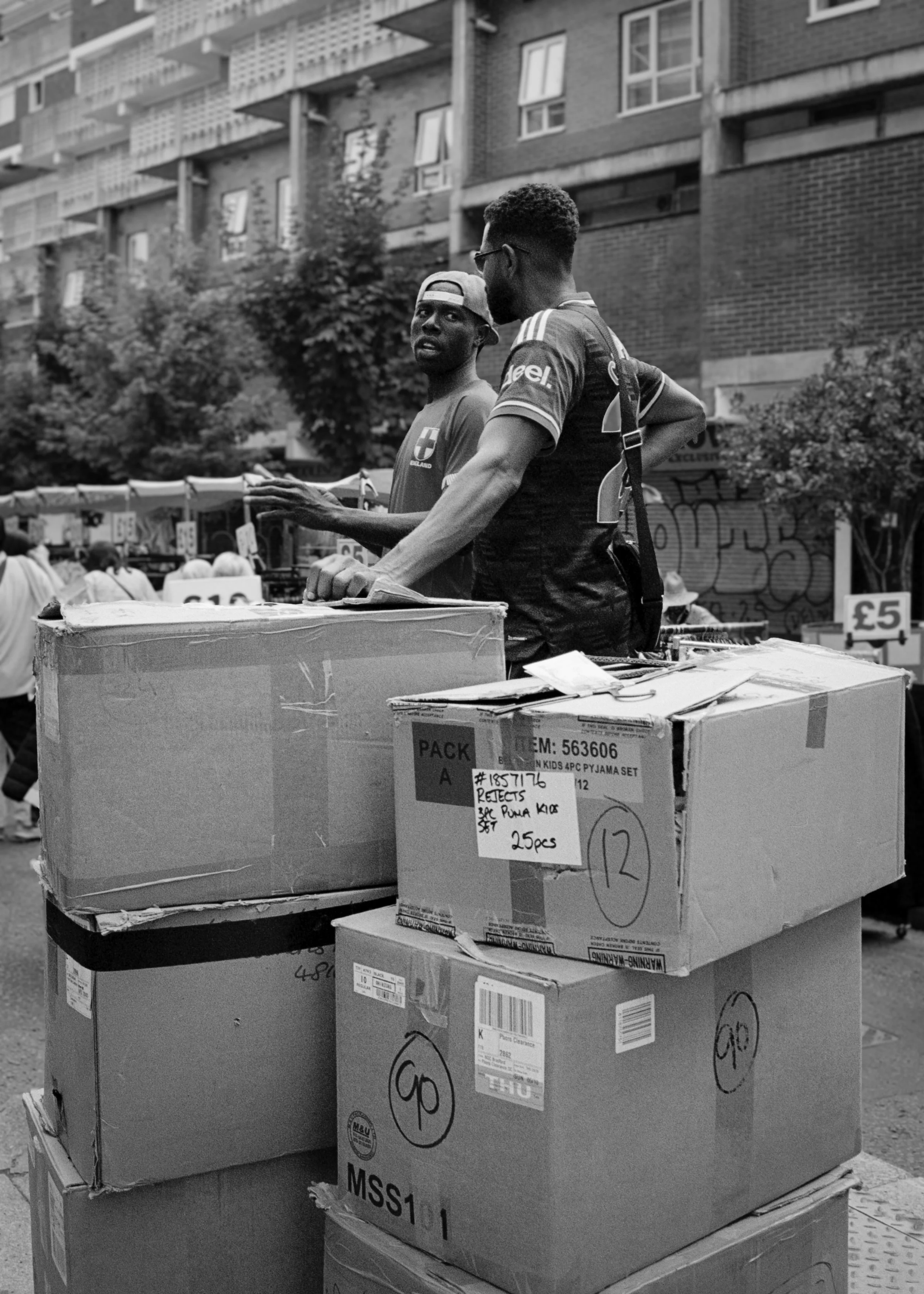 BY THE BOXES : Petticoat Lane,
August 2026. OM2 | TRI-X  (rated 640)  | 35mm at f11