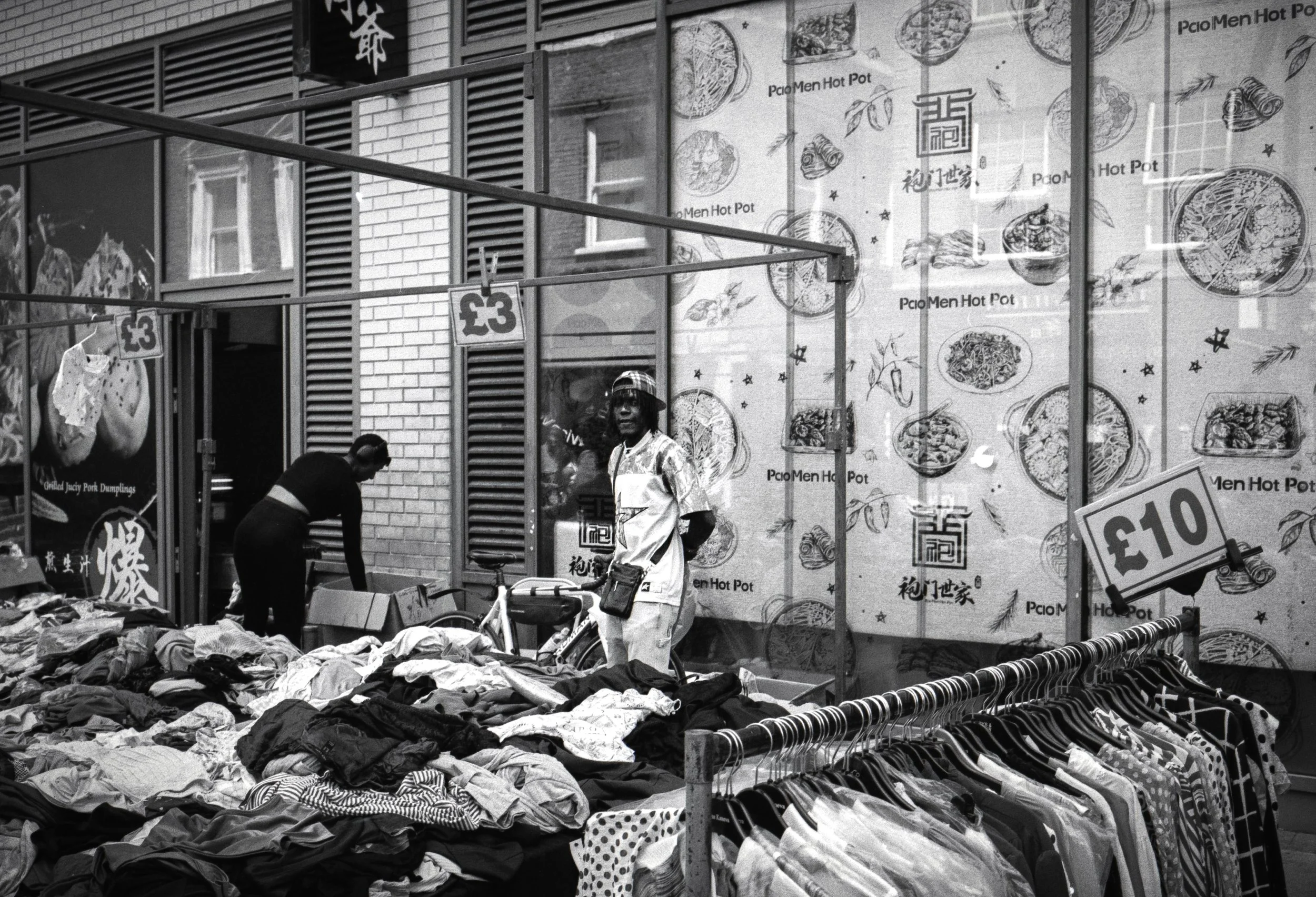 STANDING BY WALL : Petticoat Lane,
August 2026. OM2 | TRI-X  (rated 640)  | 35mm at f11