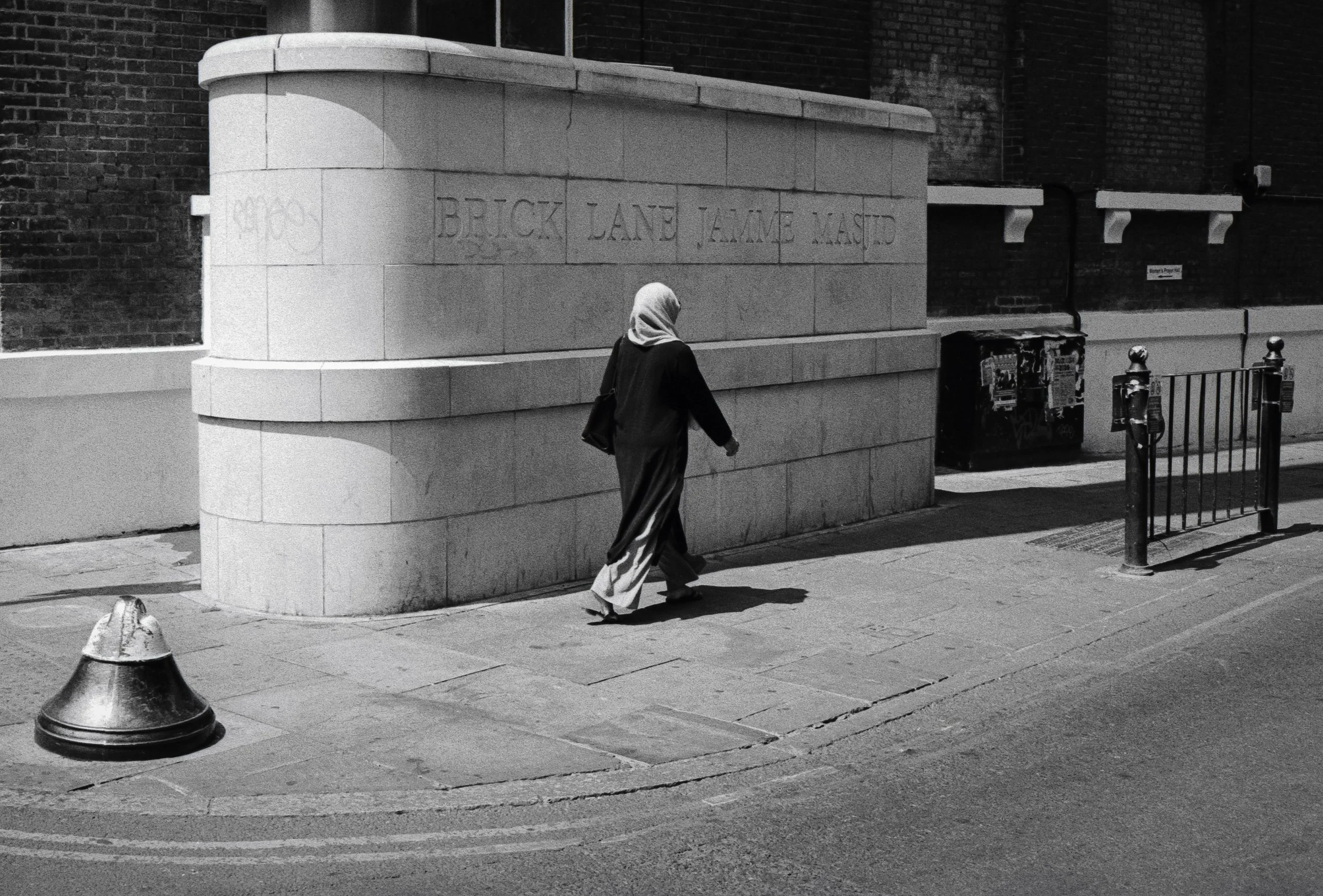 Lady walking past mosque sign.jpg