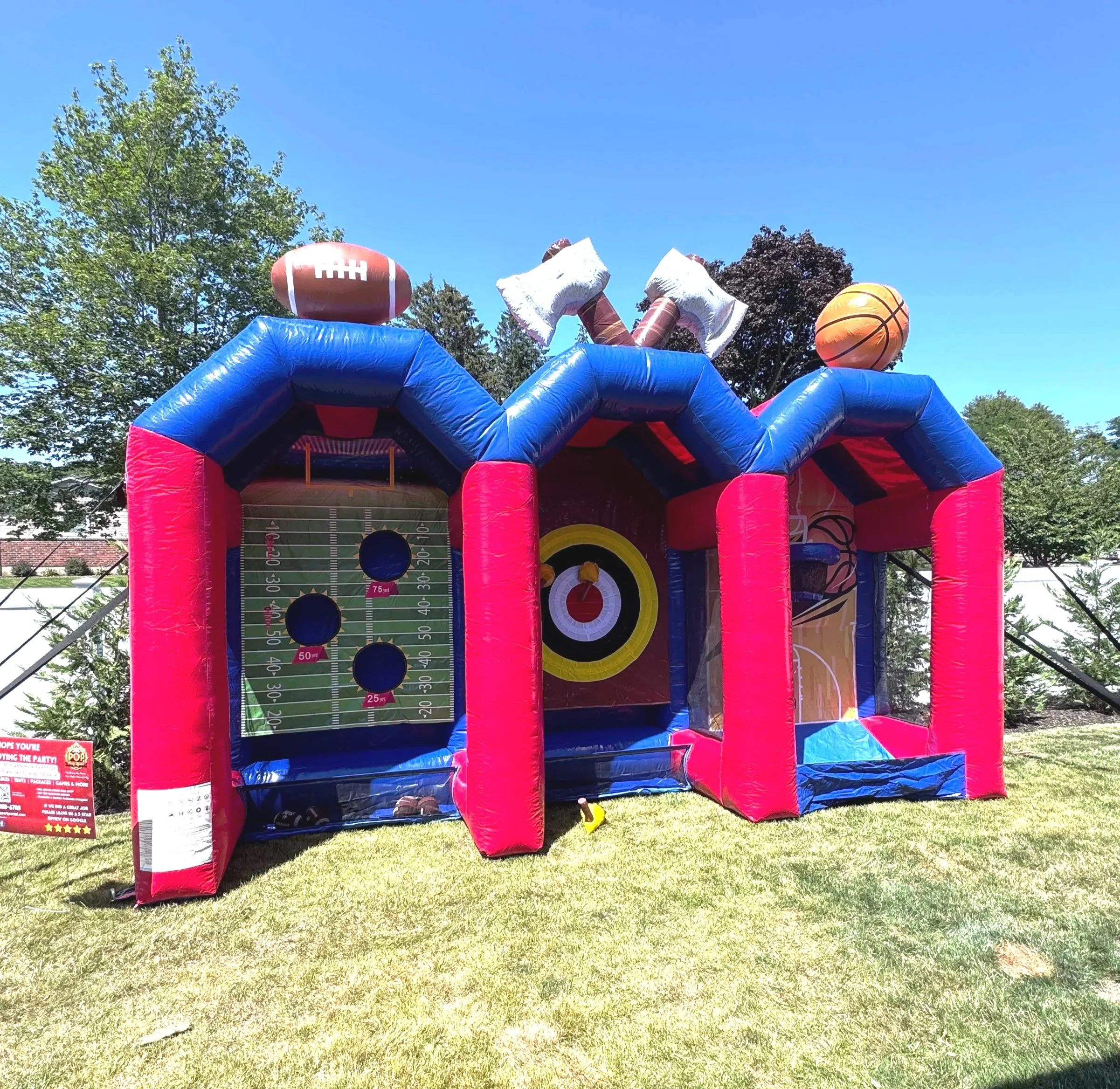 Inflatable sports game with football, basketball, and axe throwing.